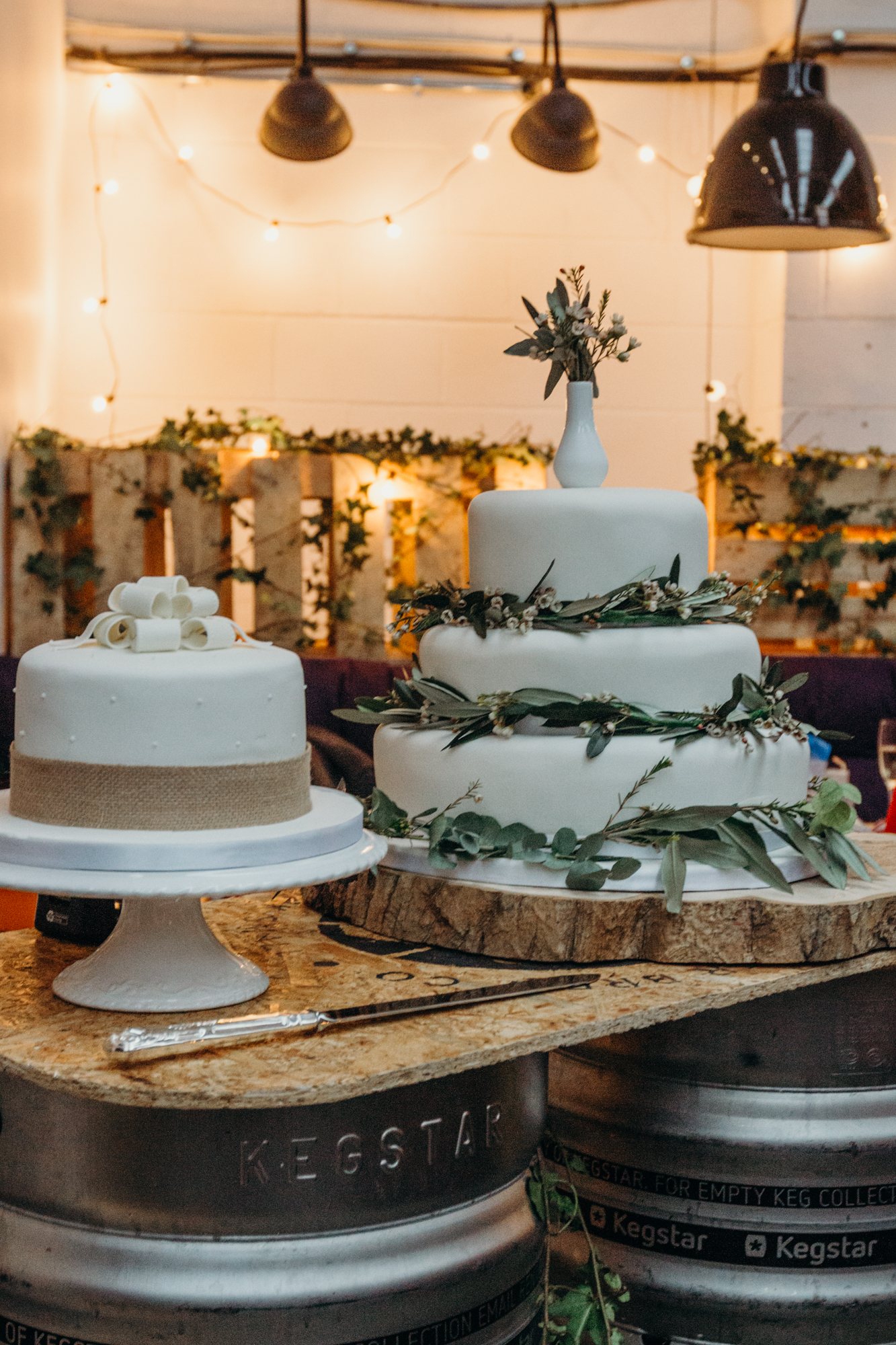 Elegant wedding cake display with fresh greenery at Small Beer Brewery.