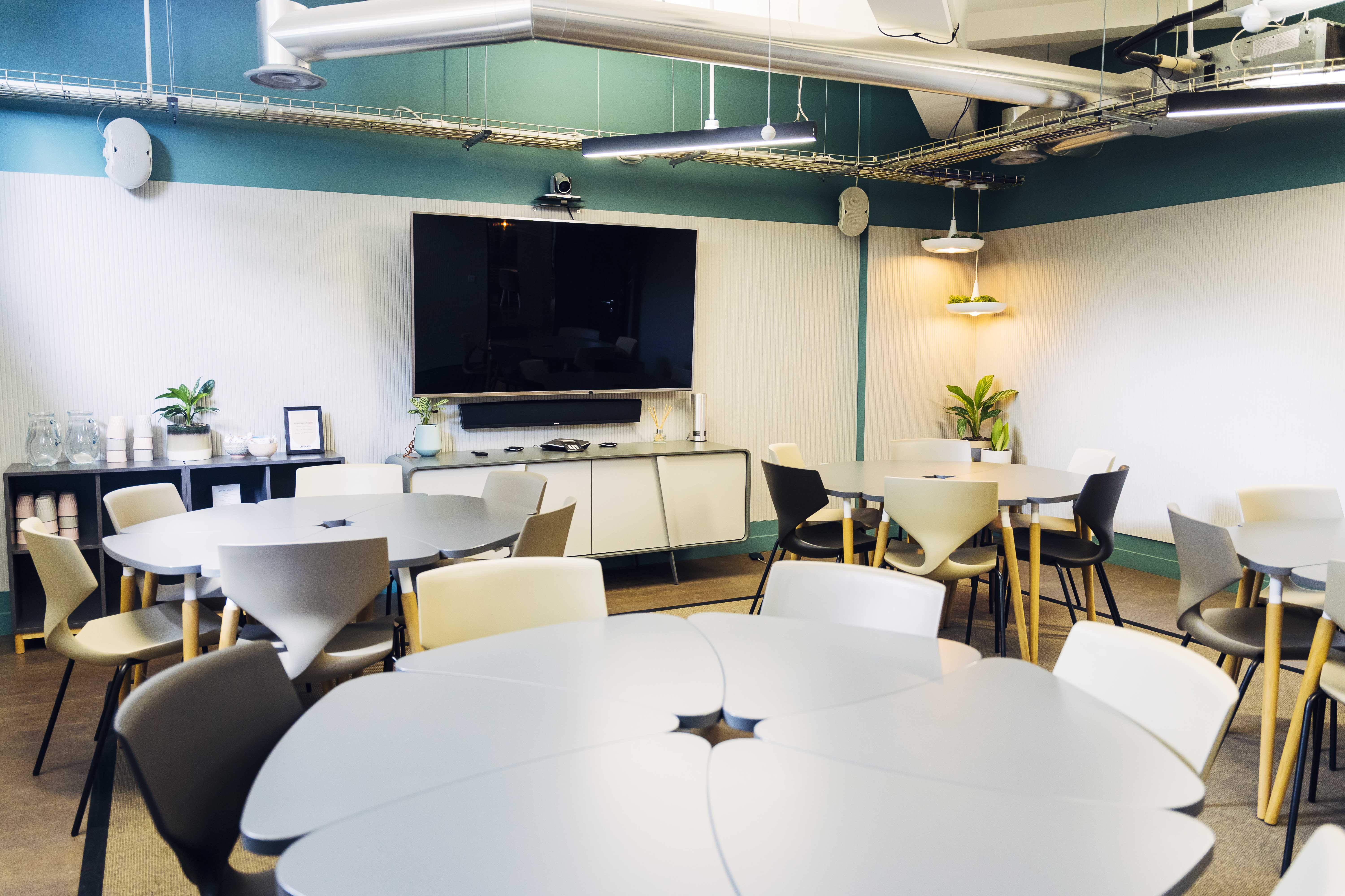 Modern meeting room with round tables, perfect for workshops and team meetings.