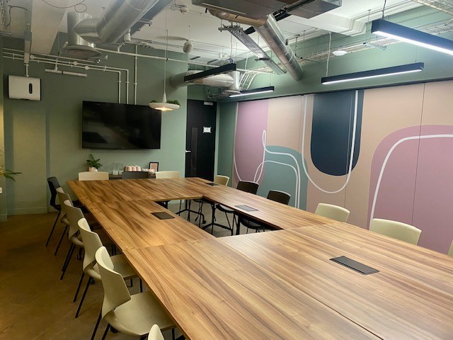 Modern meeting room LG.05 at Uncommon Borough with a large wooden table, perfect for collaboration.
