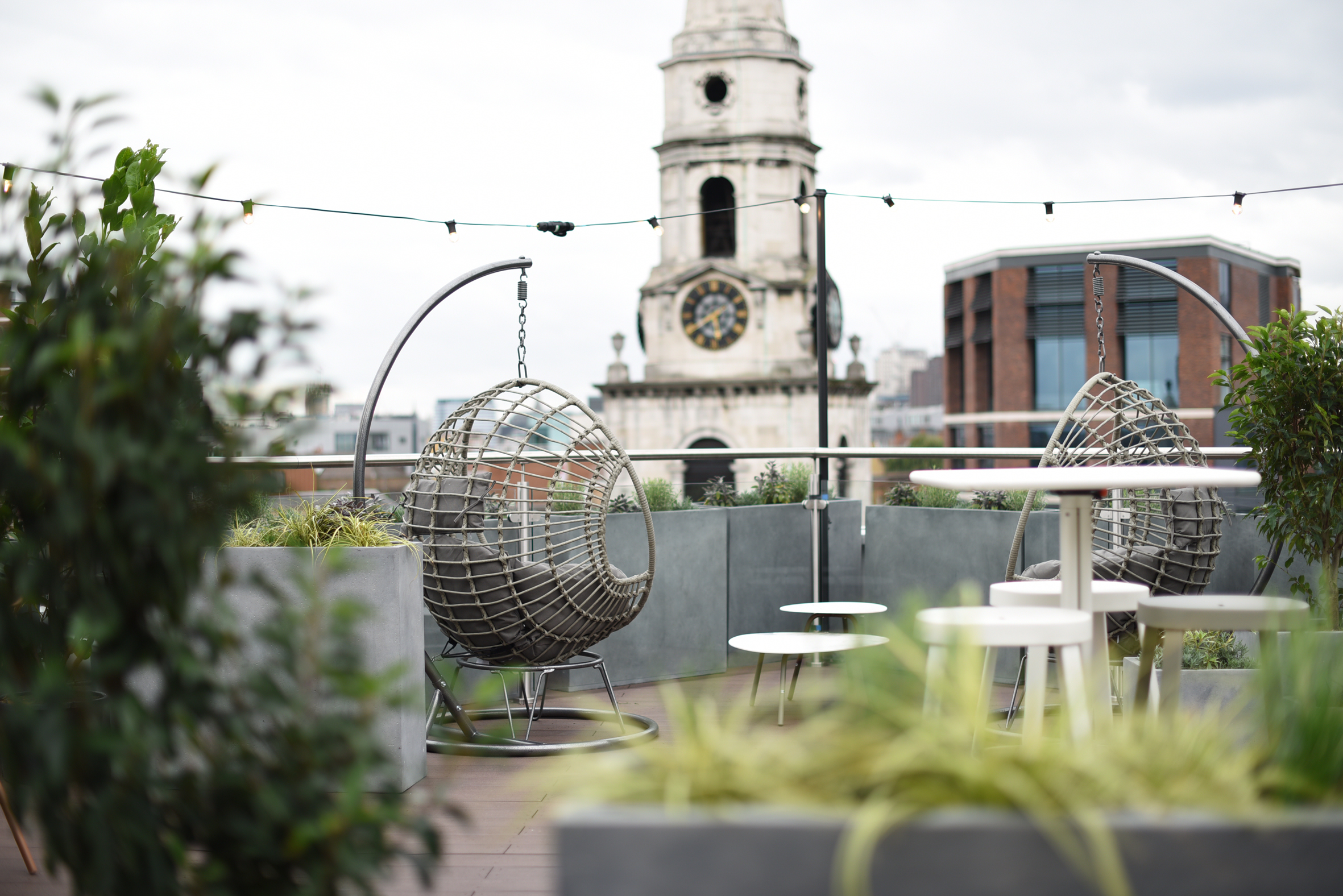 Stylish rooftop terrace with hanging chairs, perfect for networking events in the city.