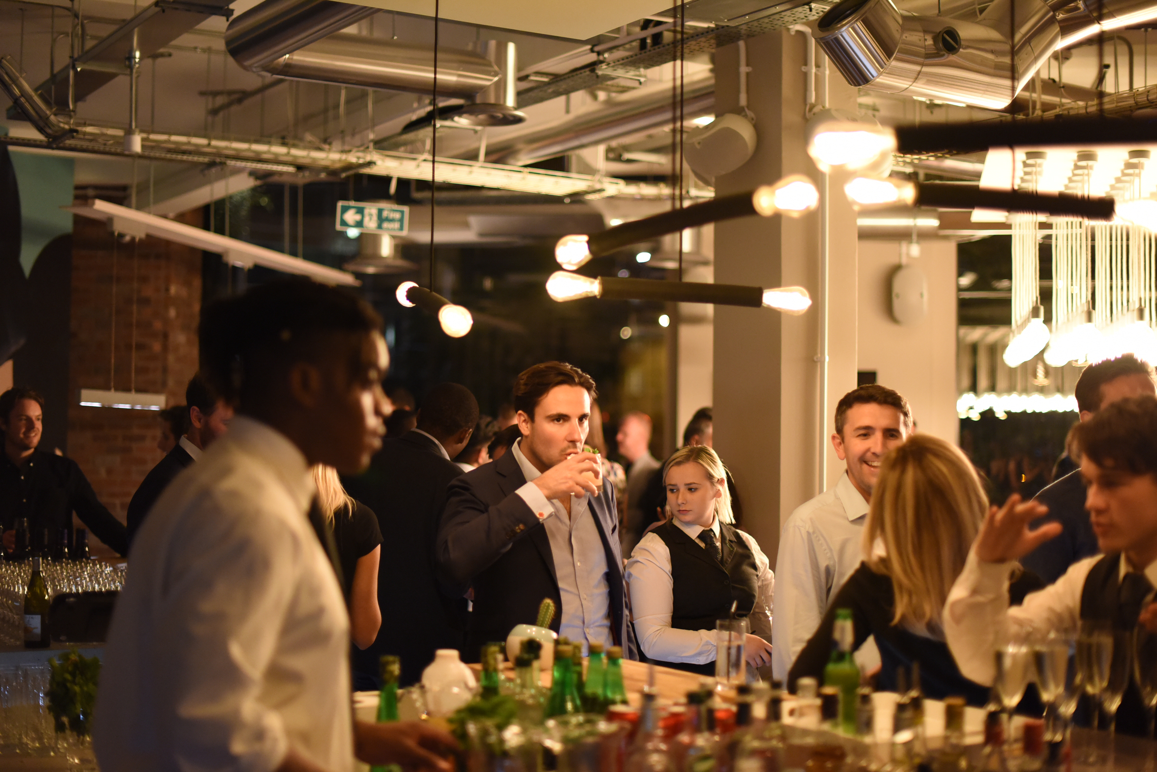 Vibrant networking event at Cafe Lounge with stylish bar and engaged attendees.