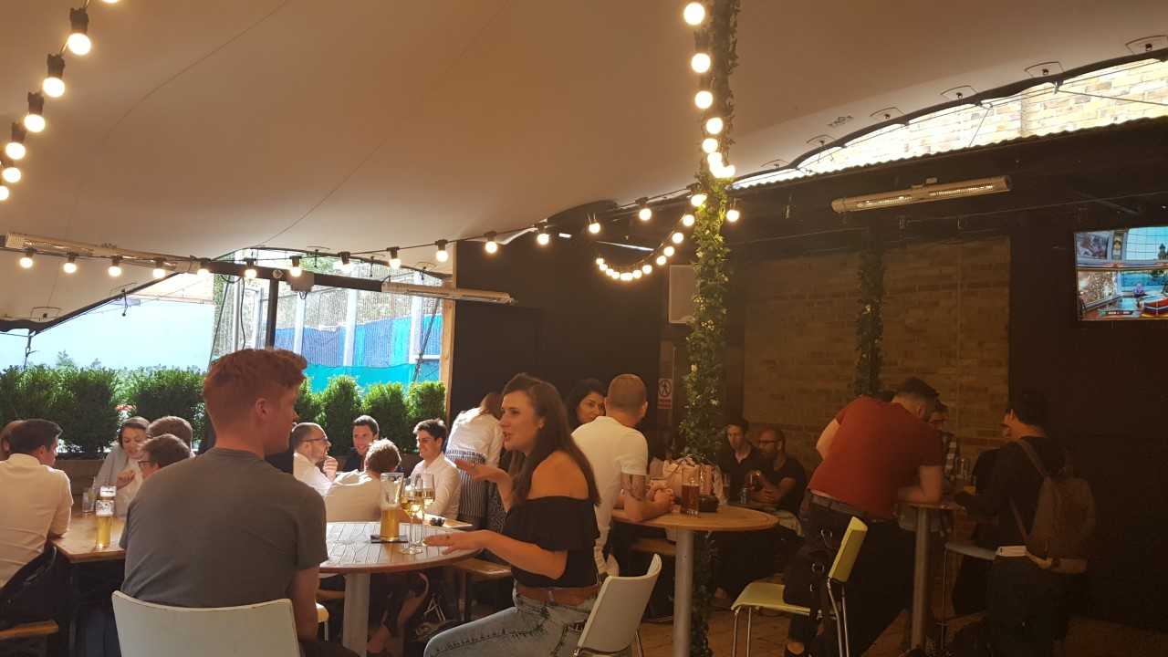 Vibrant Bermondsey Bar & Kitchen event space with string lights, ideal for networking gatherings.