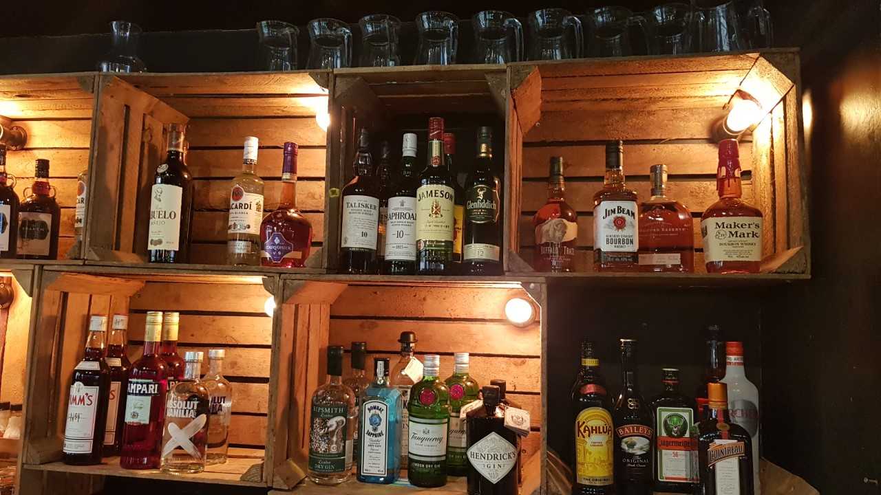 Whole Venue bar setup with spirits in wooden crates, perfect for networking events.