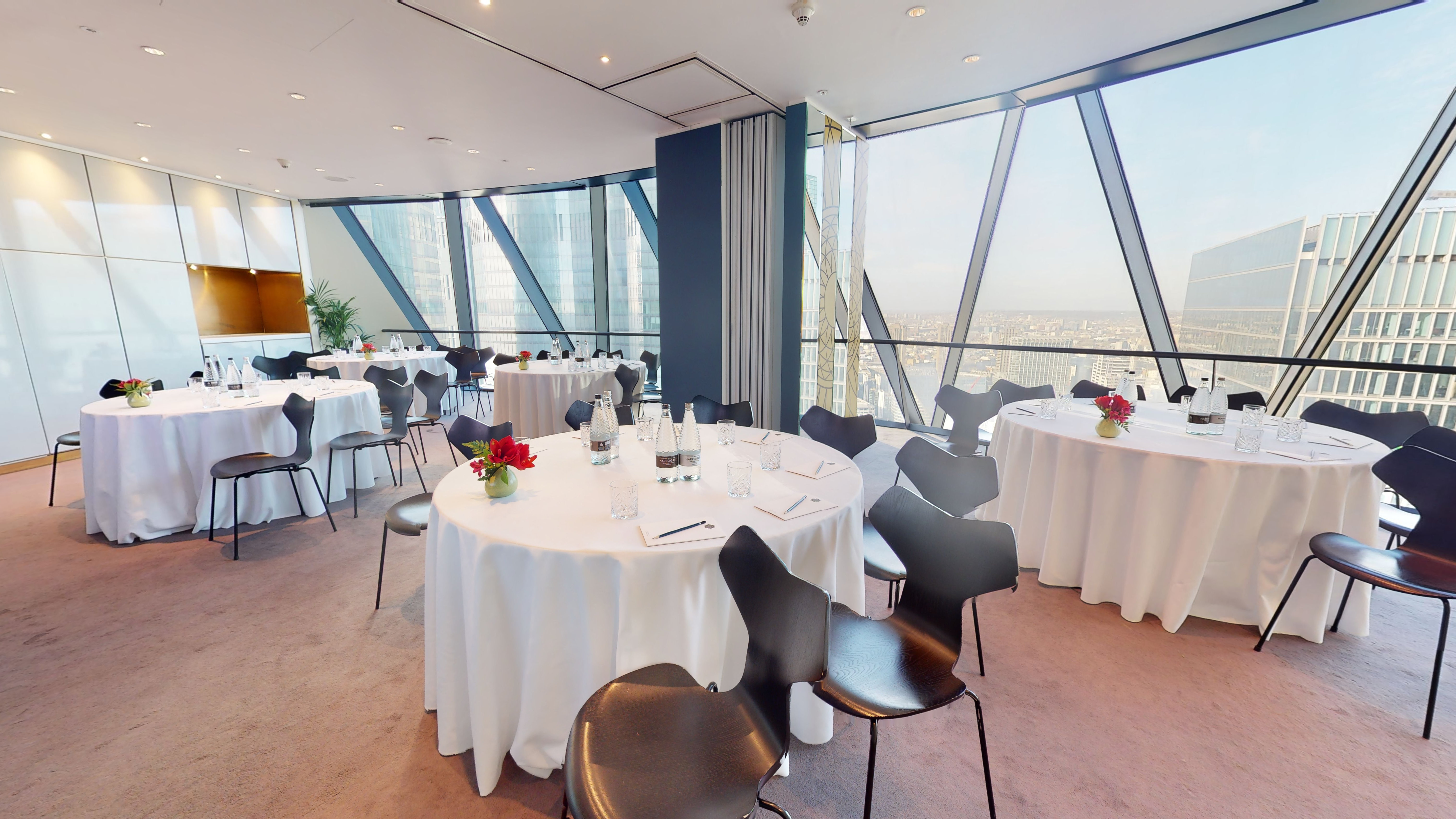 Elegant private dining rooms at Searcys, featuring round tables and city views for events.