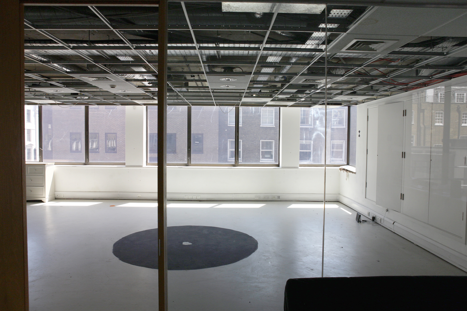 Spacious minimalist meeting room with large windows for workshops and presentations.