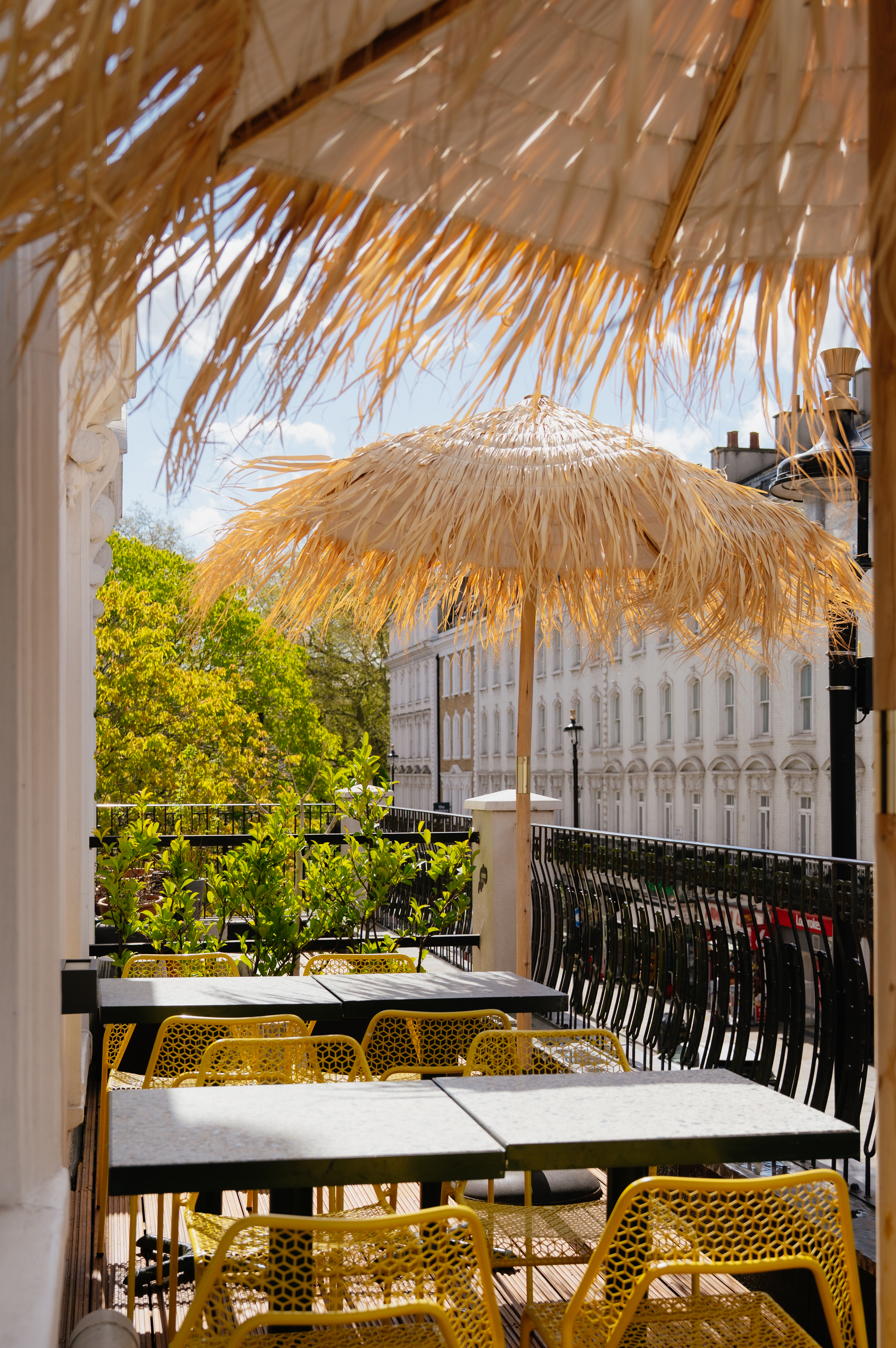 Charming outdoor Lounge & Terrace with straw umbrella, ideal for alfresco events and networking.