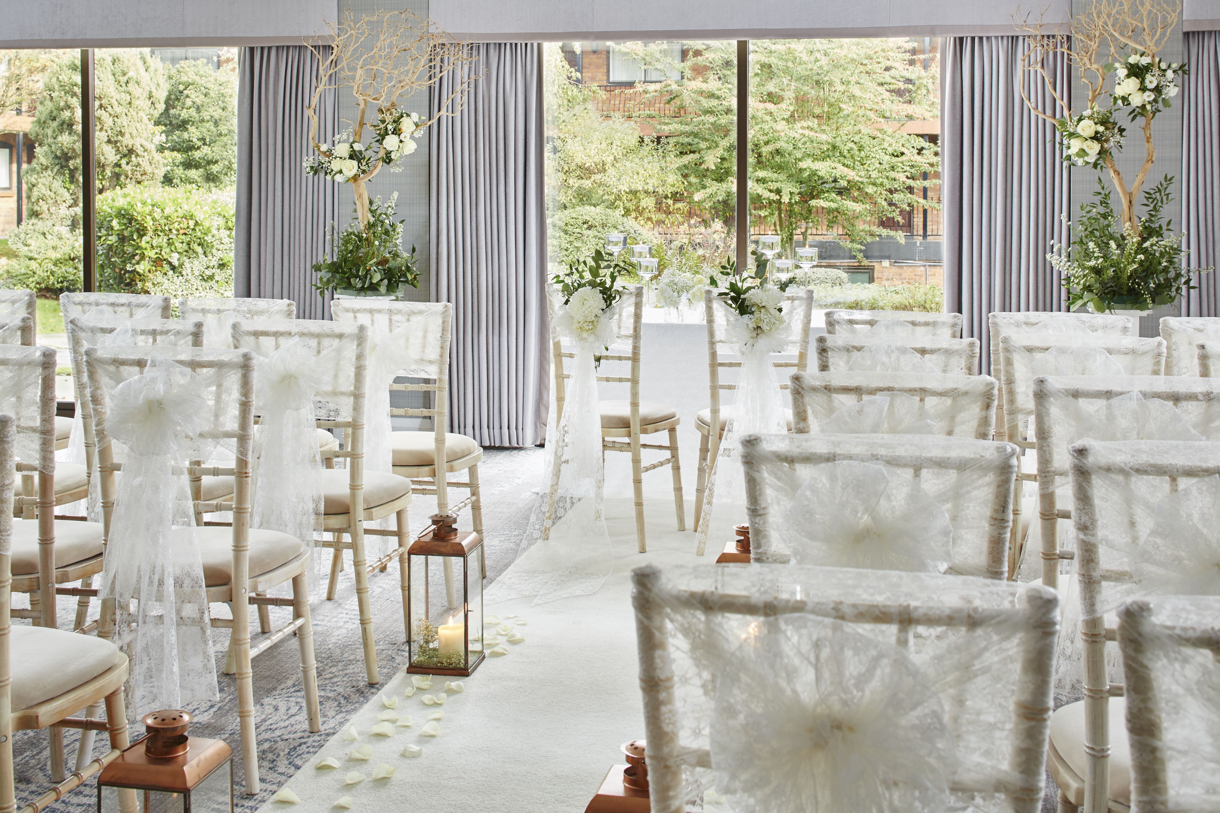 Elegant wedding venue with white chairs and floral accents at Delta Hotels Manchester.