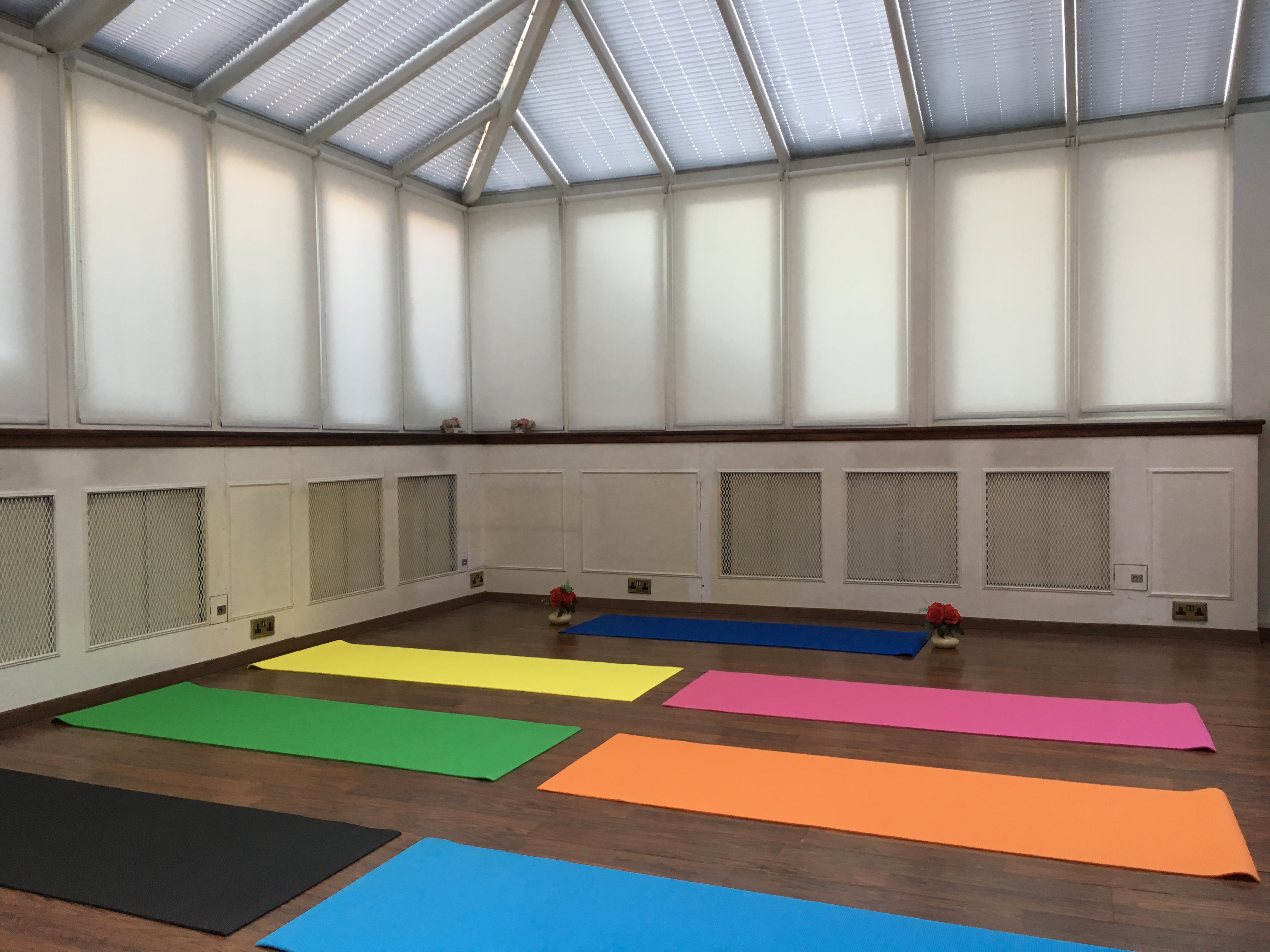 Bright yoga studio with colorful mats, ideal for wellness events and mindfulness workshops.