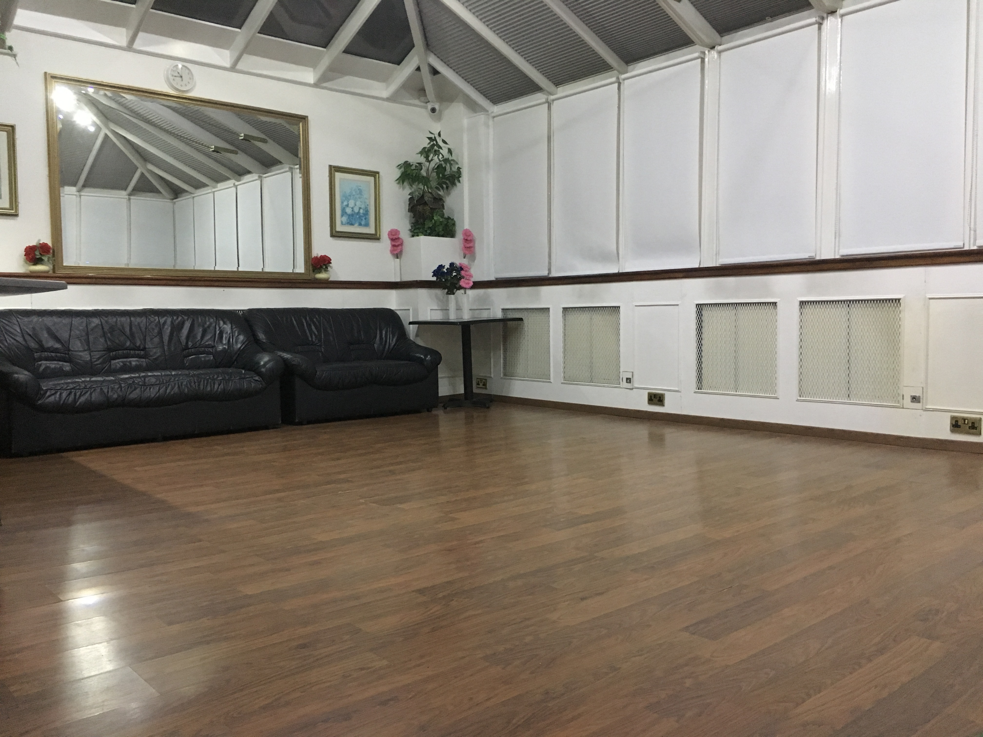 Spacious meeting room with leather sofas, ideal for workshops and gatherings.