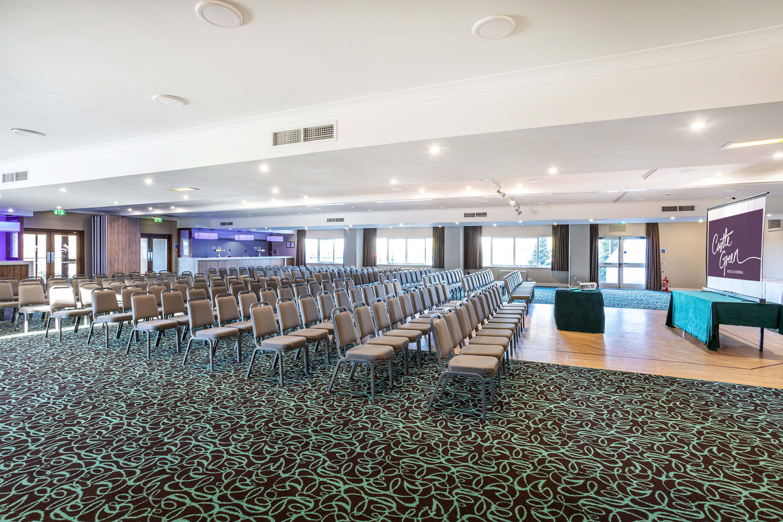 Spacious conference venue at Castle Green Hotel with elegant decor and natural light.