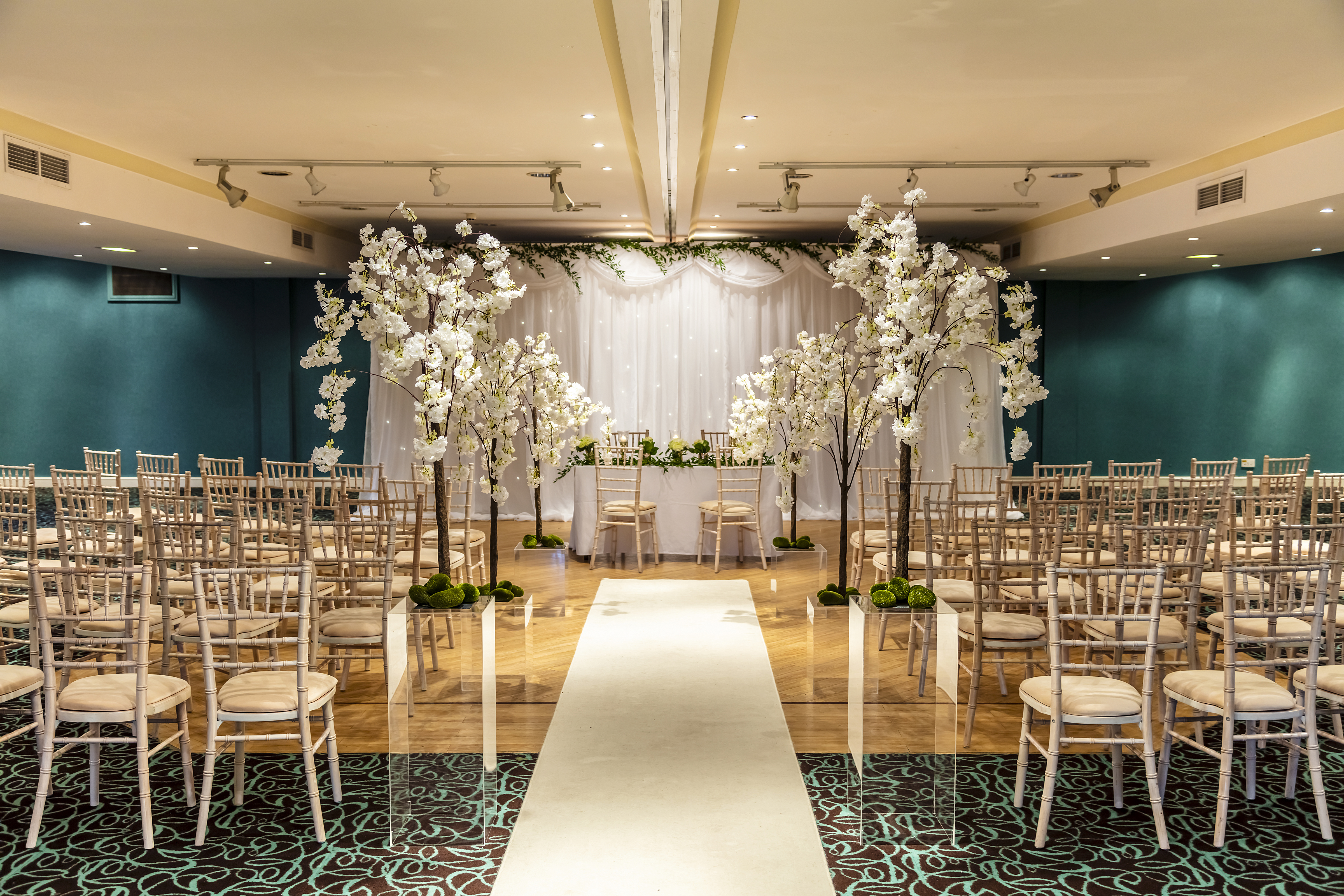 Elegant wedding venue at Castle Green Hotel with white floral decor and soft lighting.