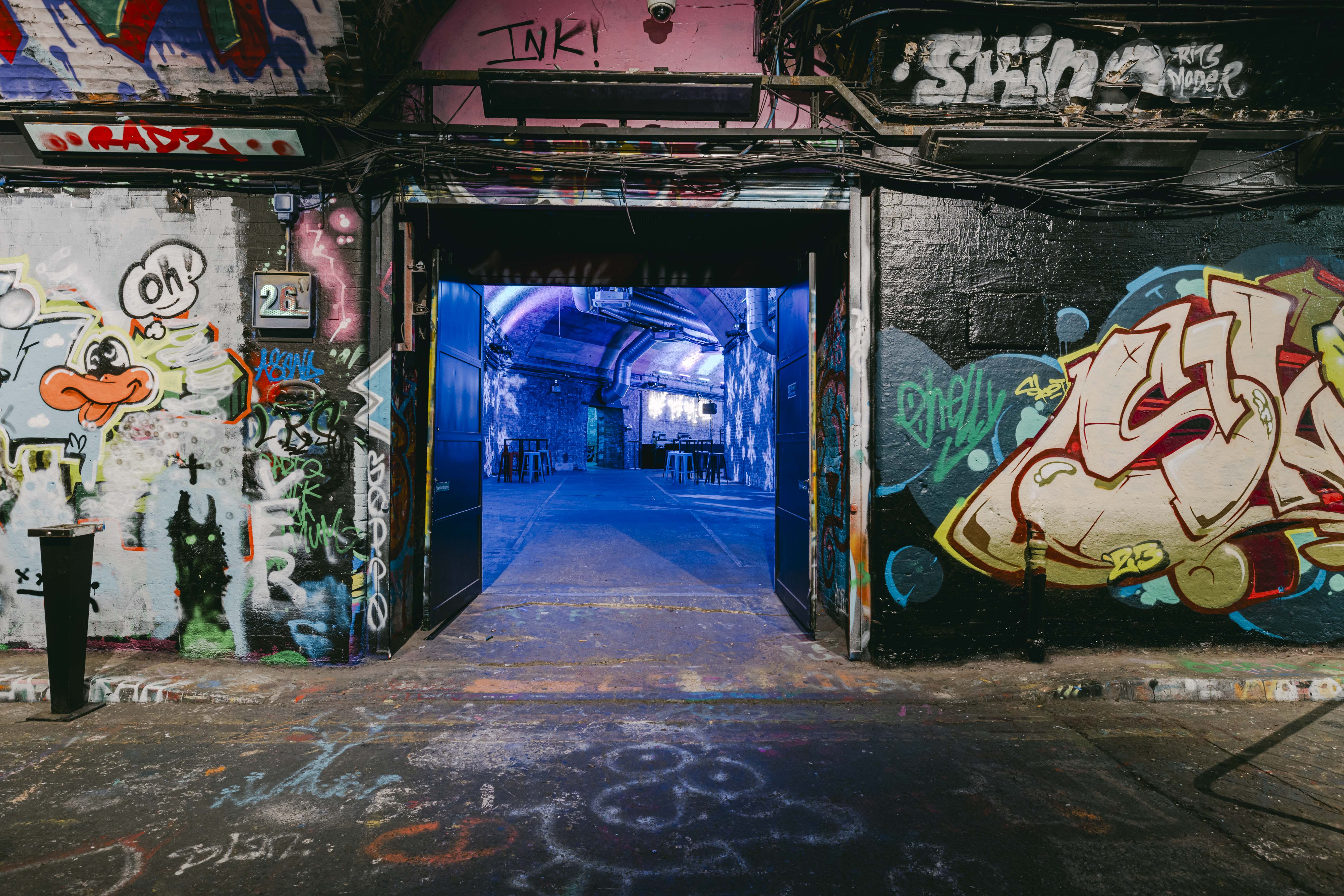 Urban venue with graffiti entrance, ideal for creative events and exhibitions.