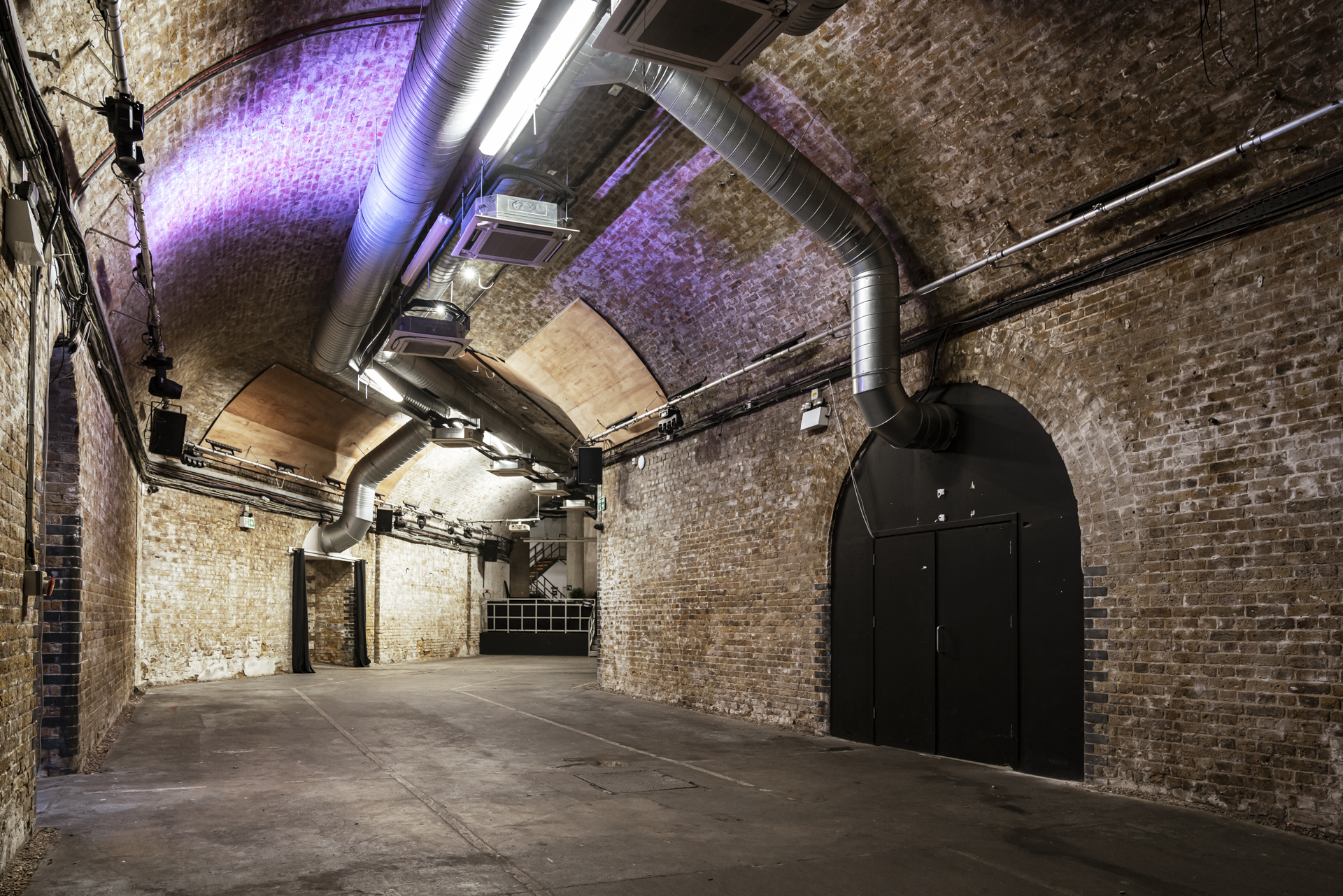 Versatile underground event space with exposed brick walls for corporate gatherings.
