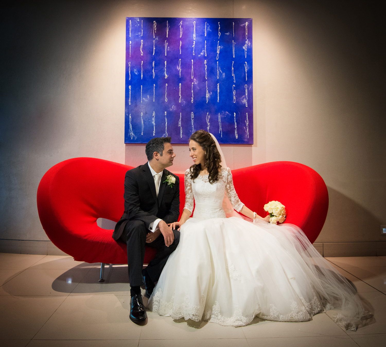 Stylish couple on red sofa at Riverside 4, Crowne Plaza Marlow for elegant weddings.