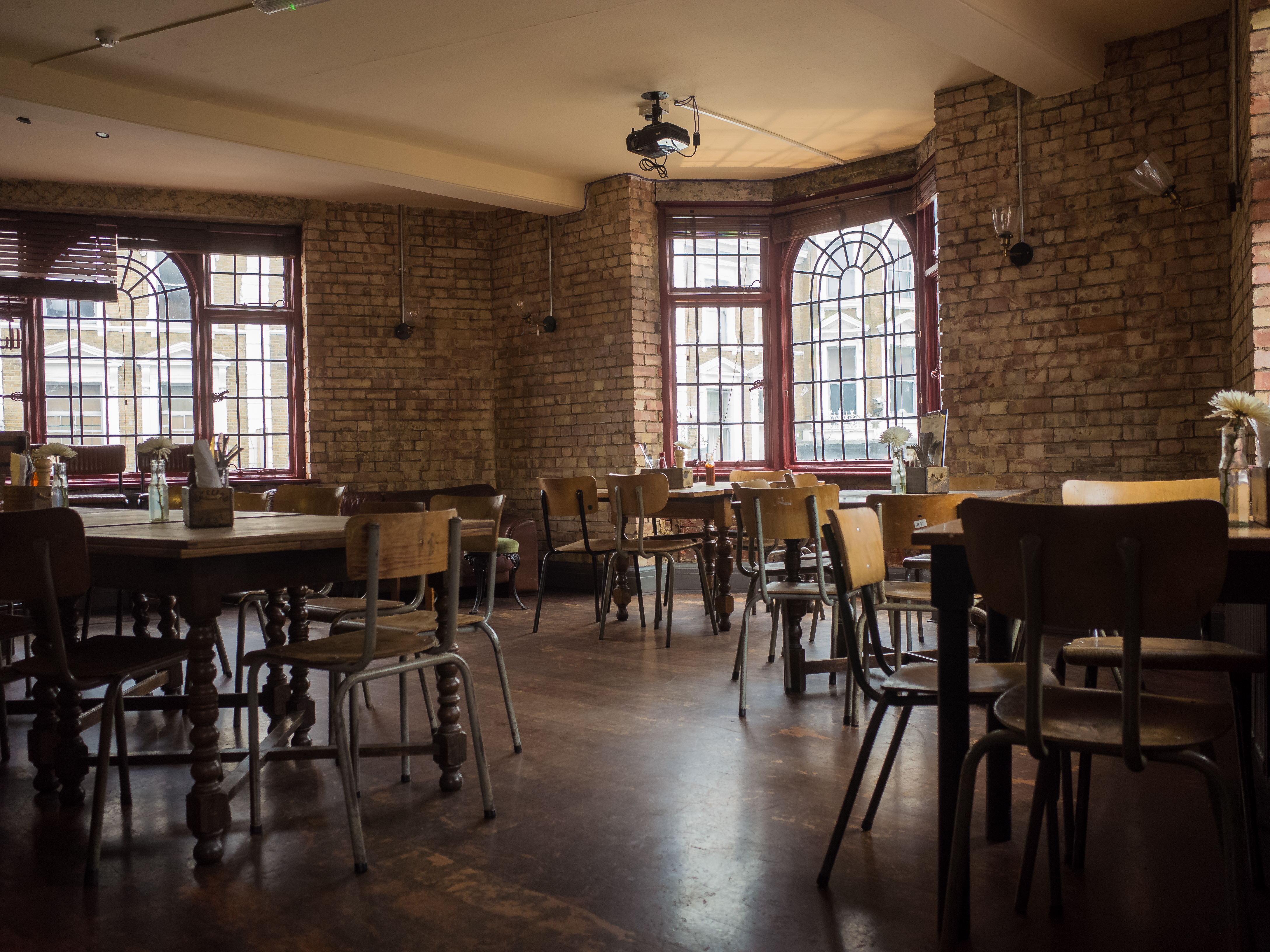 Versatile event space with exposed brick walls, ideal for meetings and gatherings.
