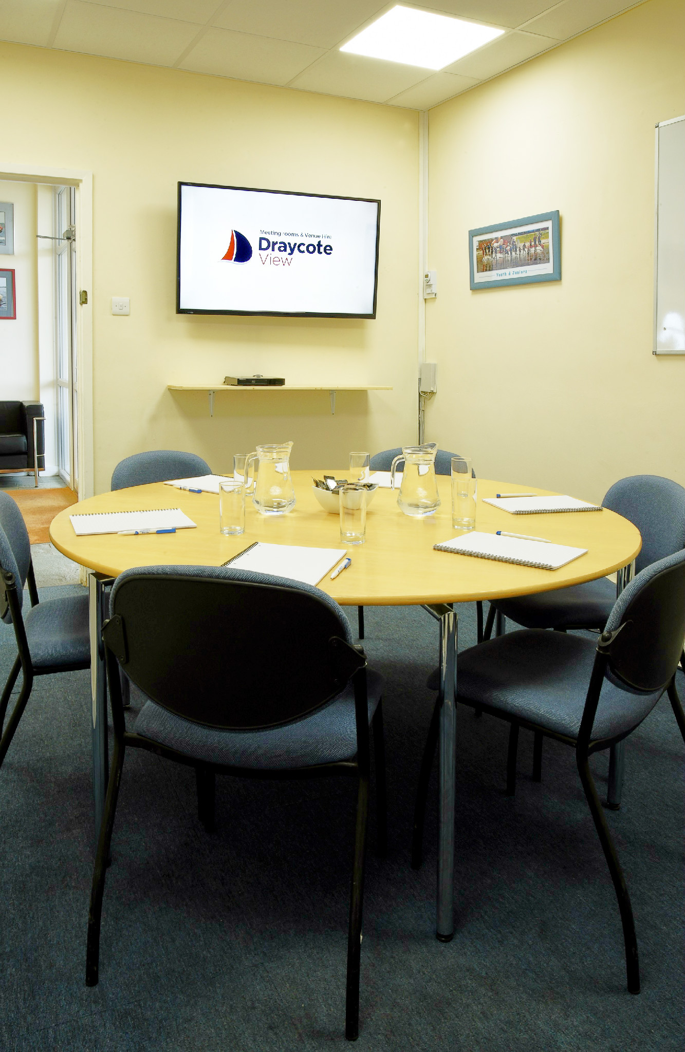 Farborough Room meeting space with round table, notepads for collaboration and brainstorming.