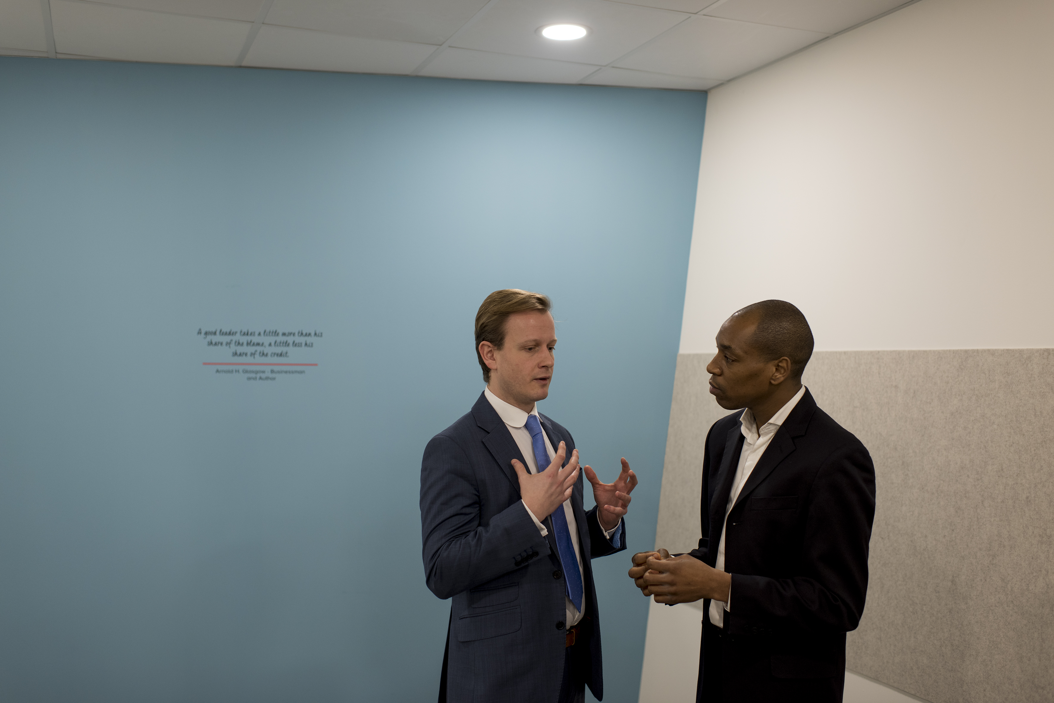 Professionals discussing event planning in a modern workshop setting with inspiring wall art.