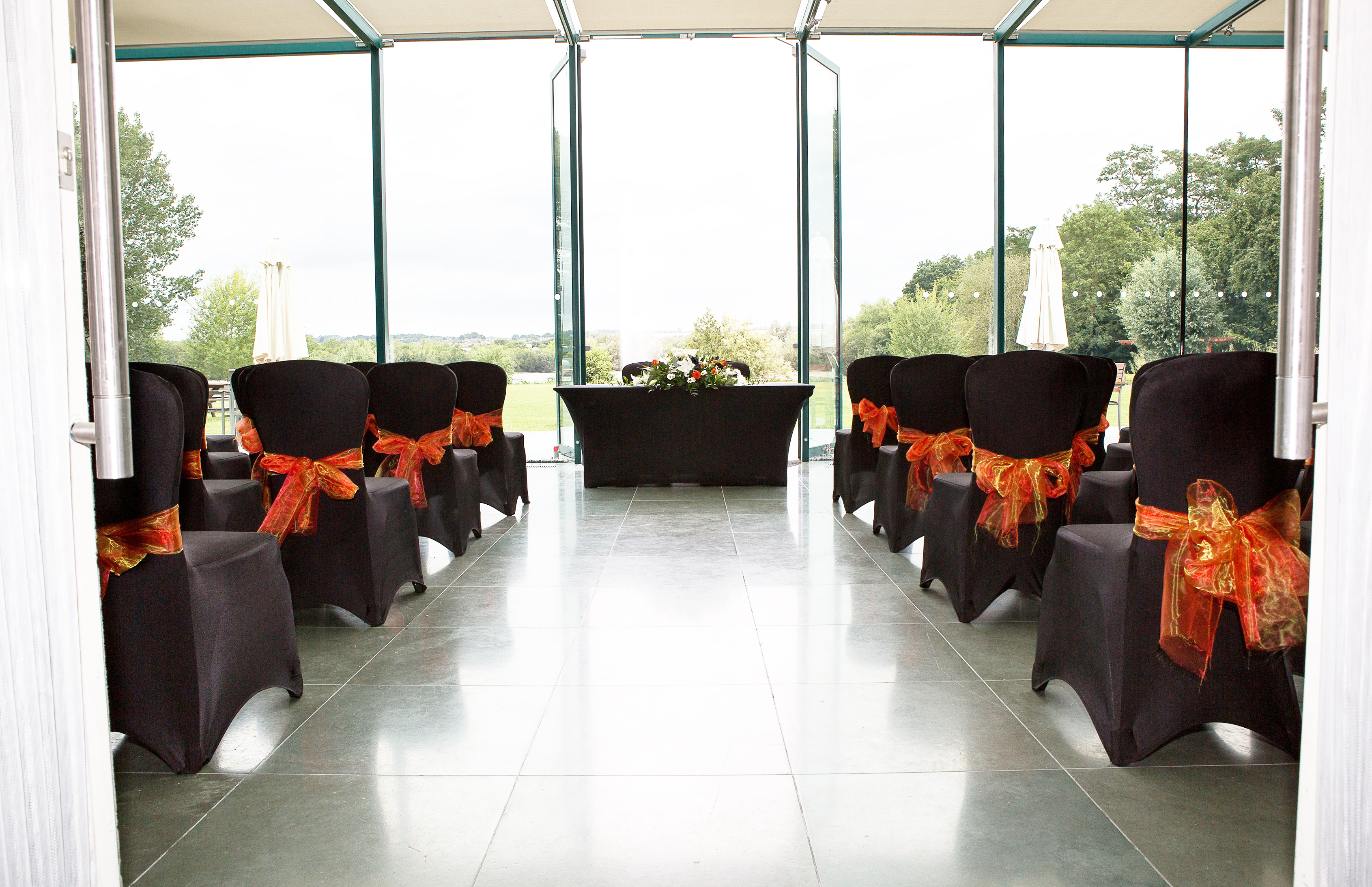 Elegant meeting space at Crowne Plaza Marlow with black chairs and orange sashes.