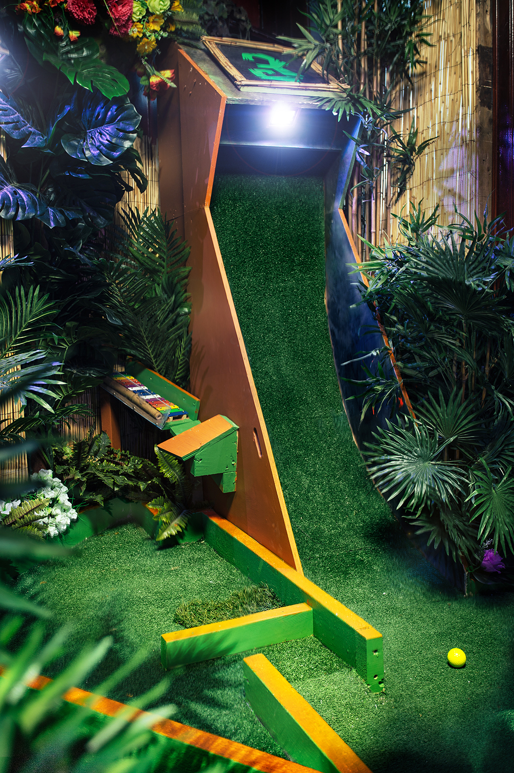 Vibrant grassy slide in The Arcade, Plonk Crazy Golf - perfect for team-building events.