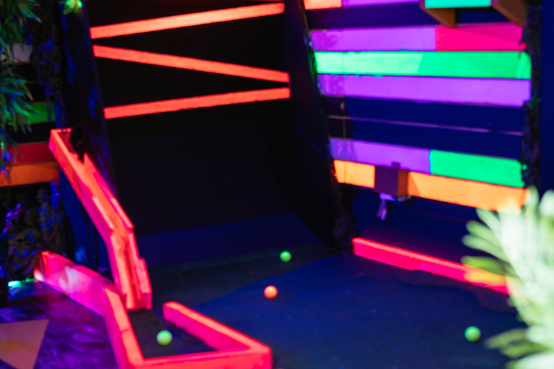Vibrant neon-lit mini-golf course at Plonk Crazy Golf, ideal for team-building events.