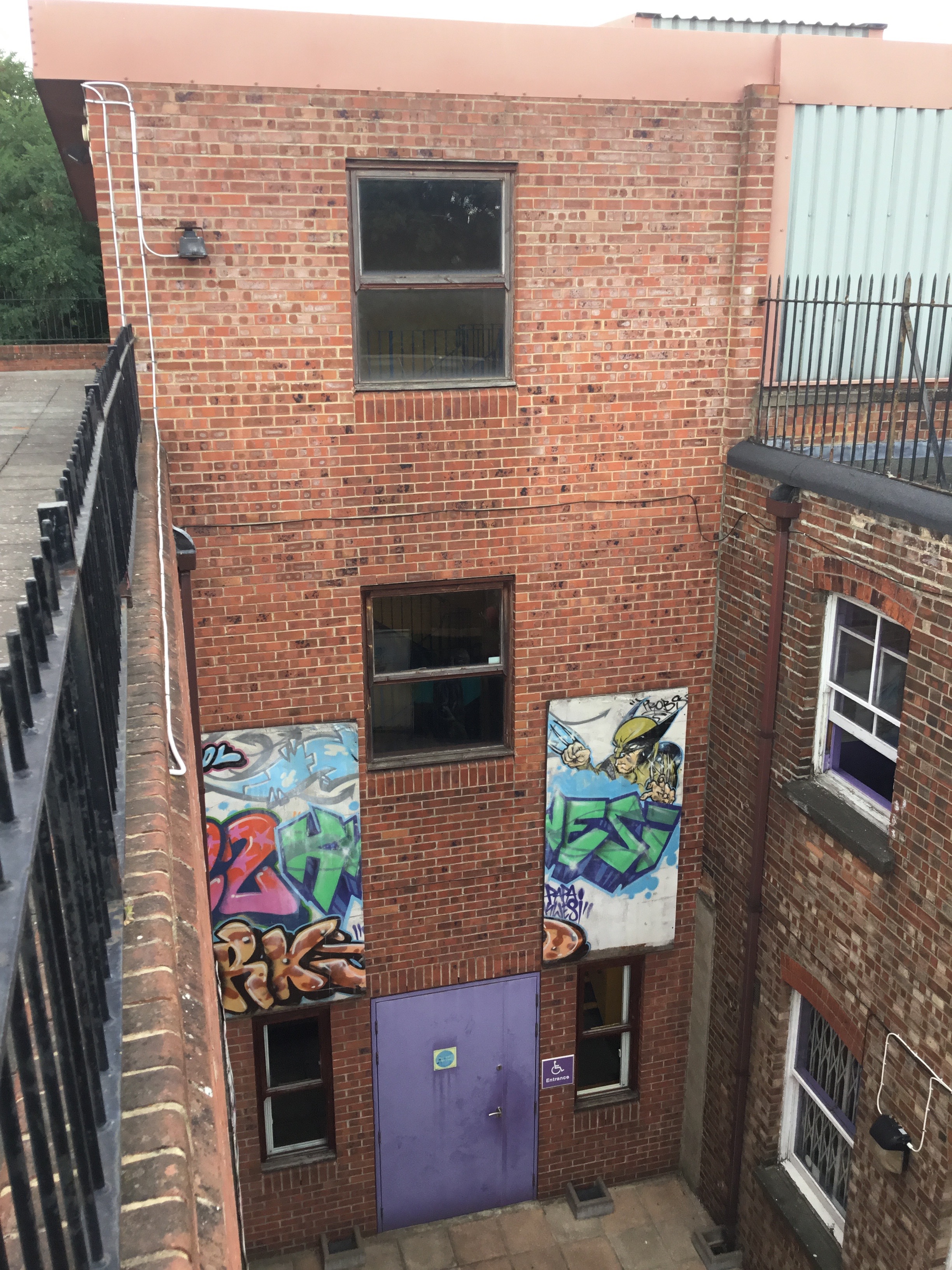 Urban rooftop space with exposed brick and graffiti for creative events.