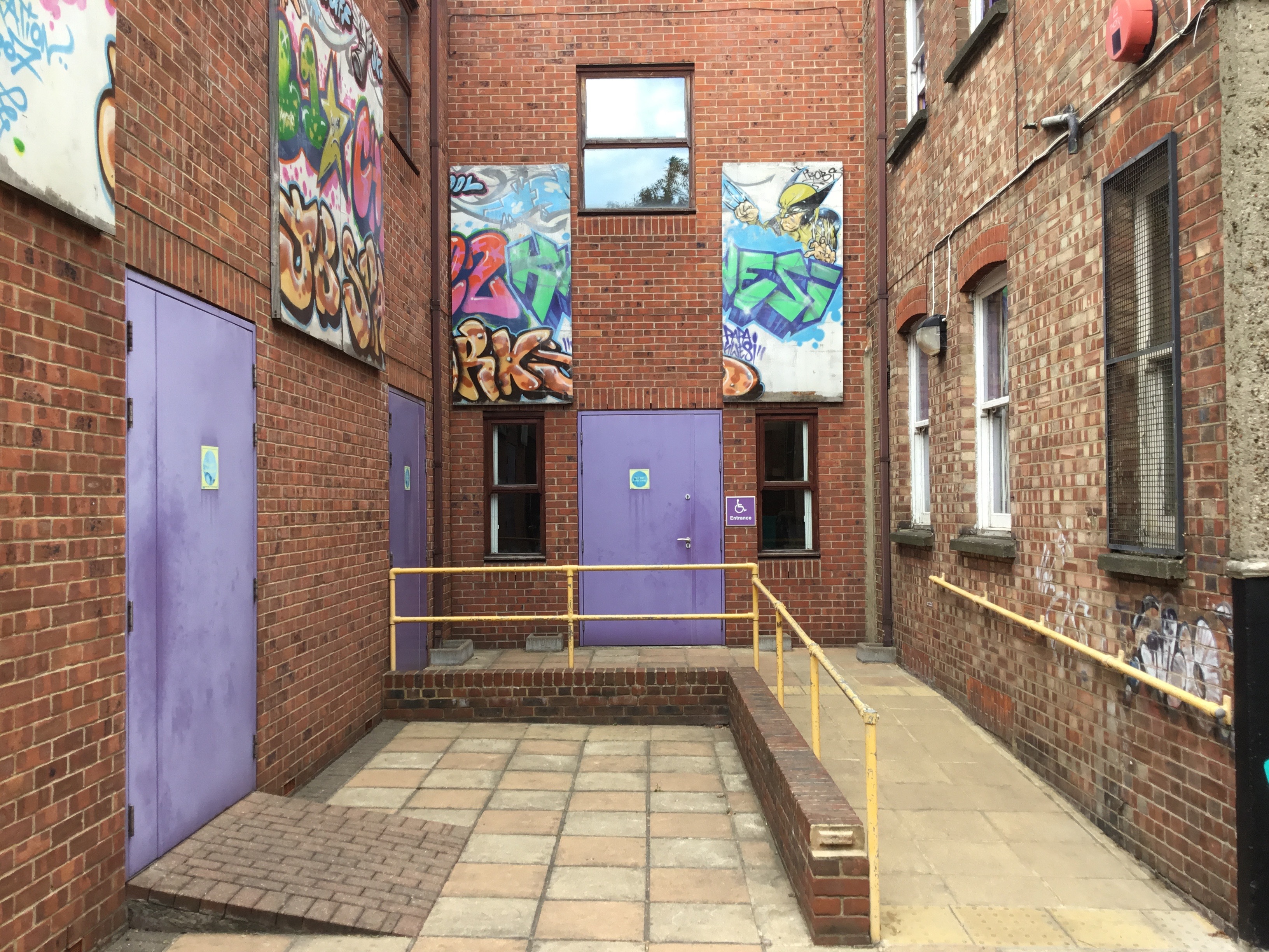 Vibrant urban courtyard with graffiti art, ideal for creative events and workshops.