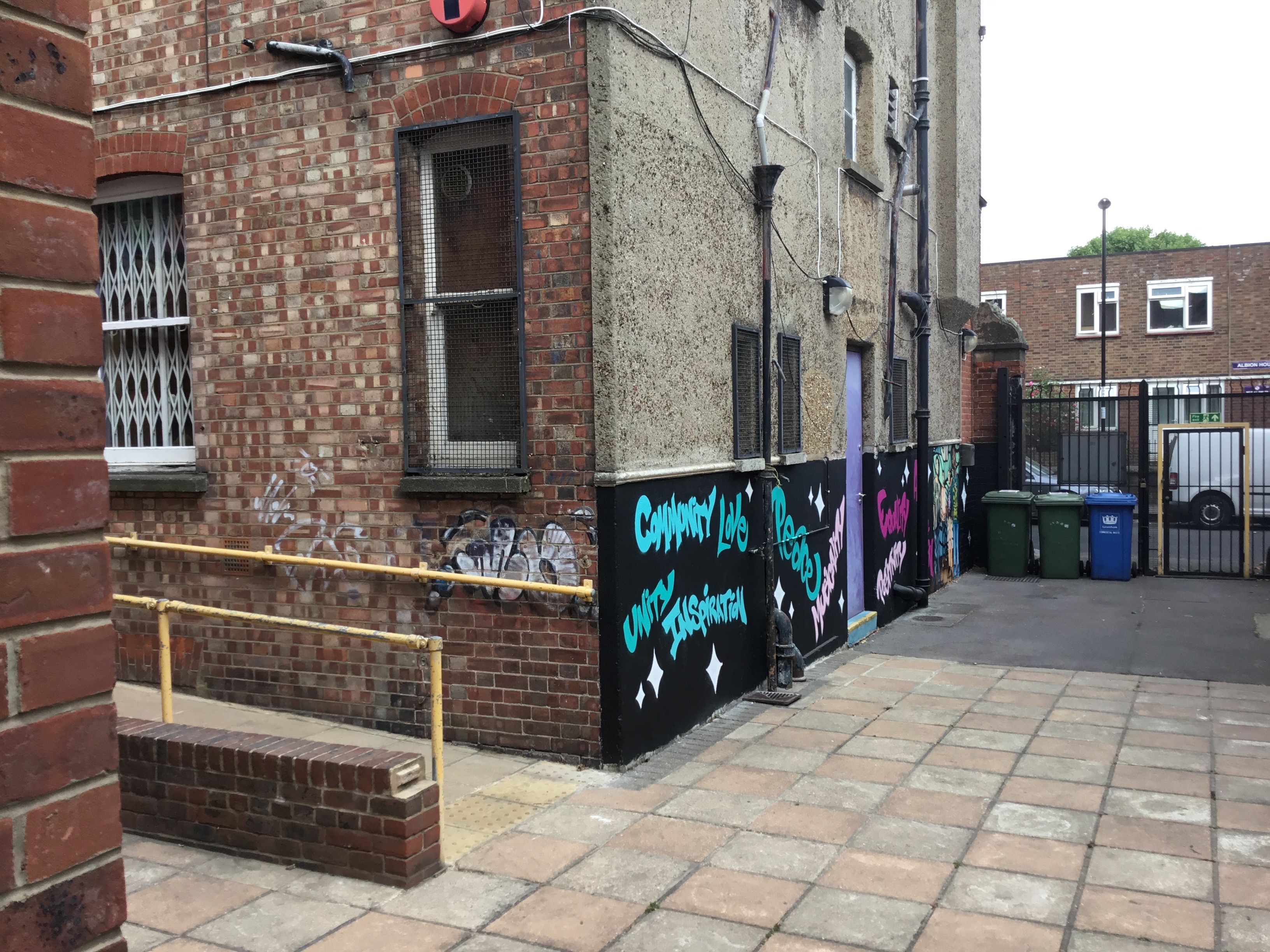 Vibrant urban courtyard with colorful graffiti for creative community events.
