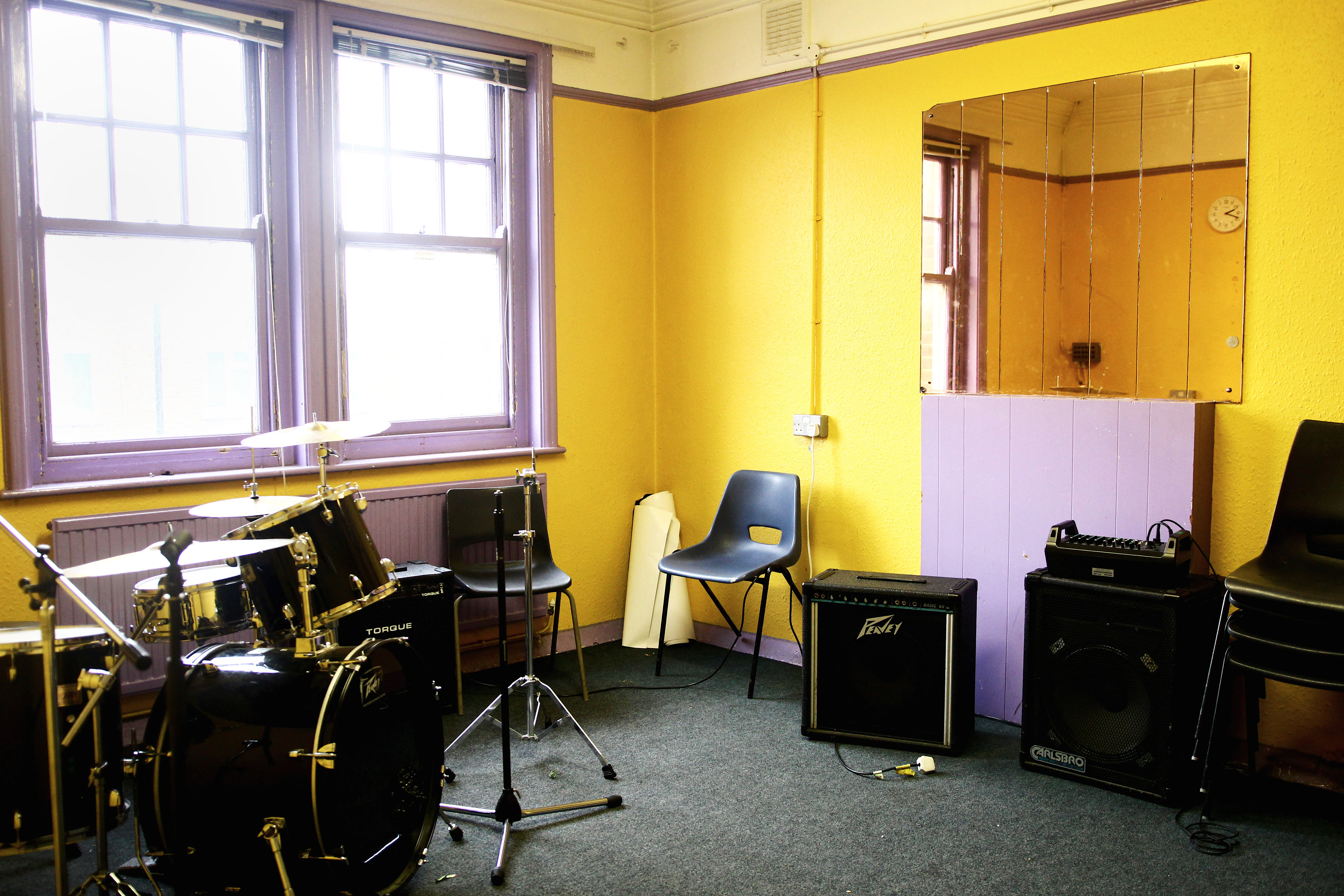 Vibrant rehearsal space with drum set, ideal for music practice and creative workshops.