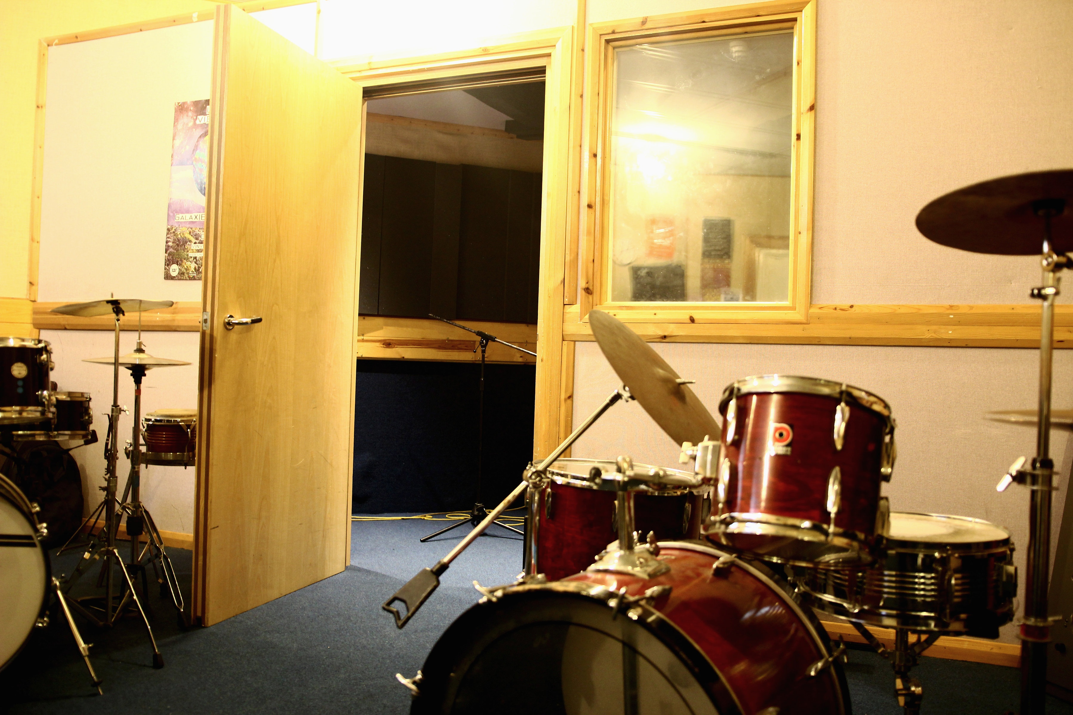 Well-equipped rehearsal space with drum set for music events and workshops.