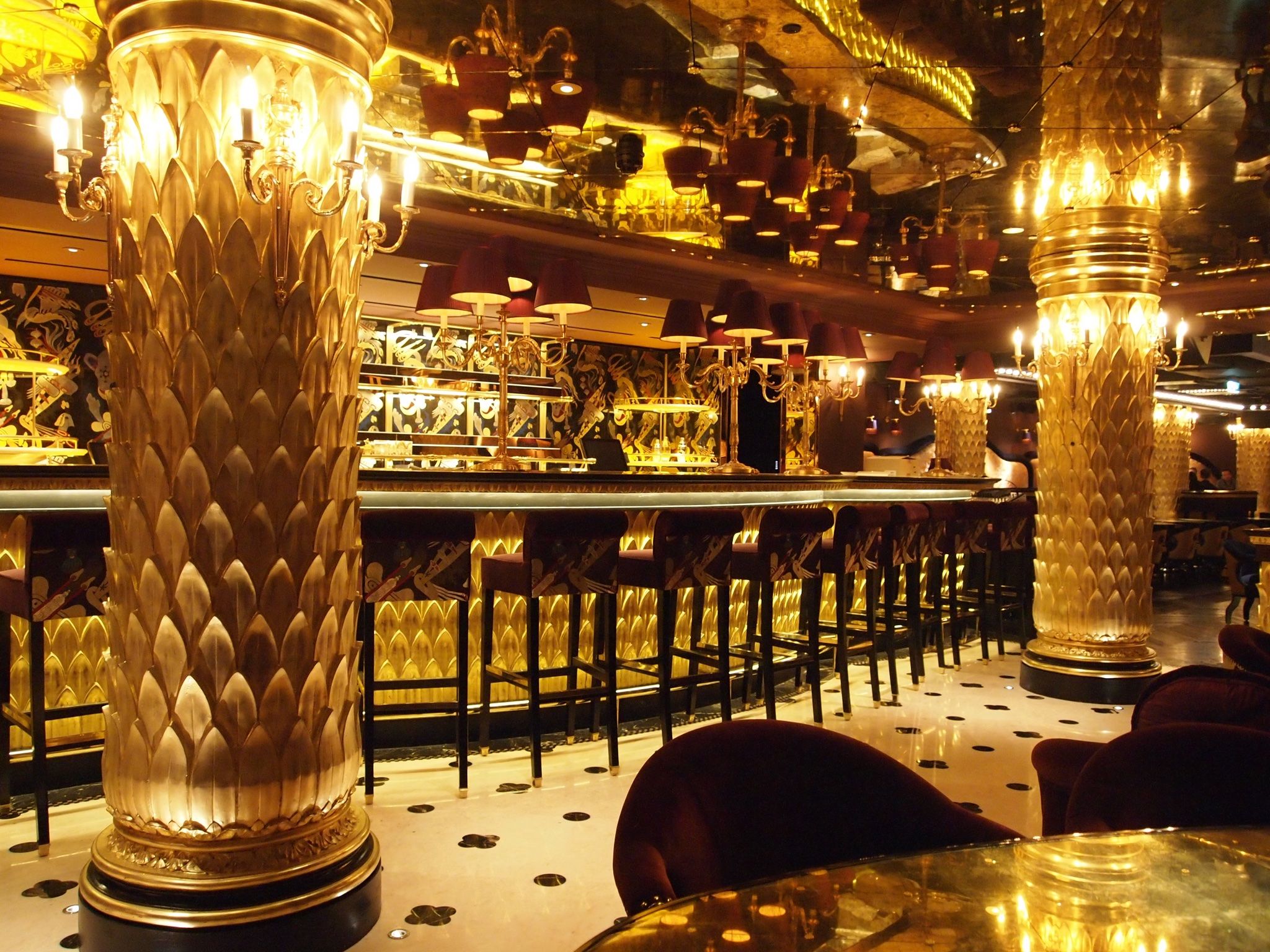 Luxurious bar at Club Chinois with golden decor, ideal for cocktail receptions.