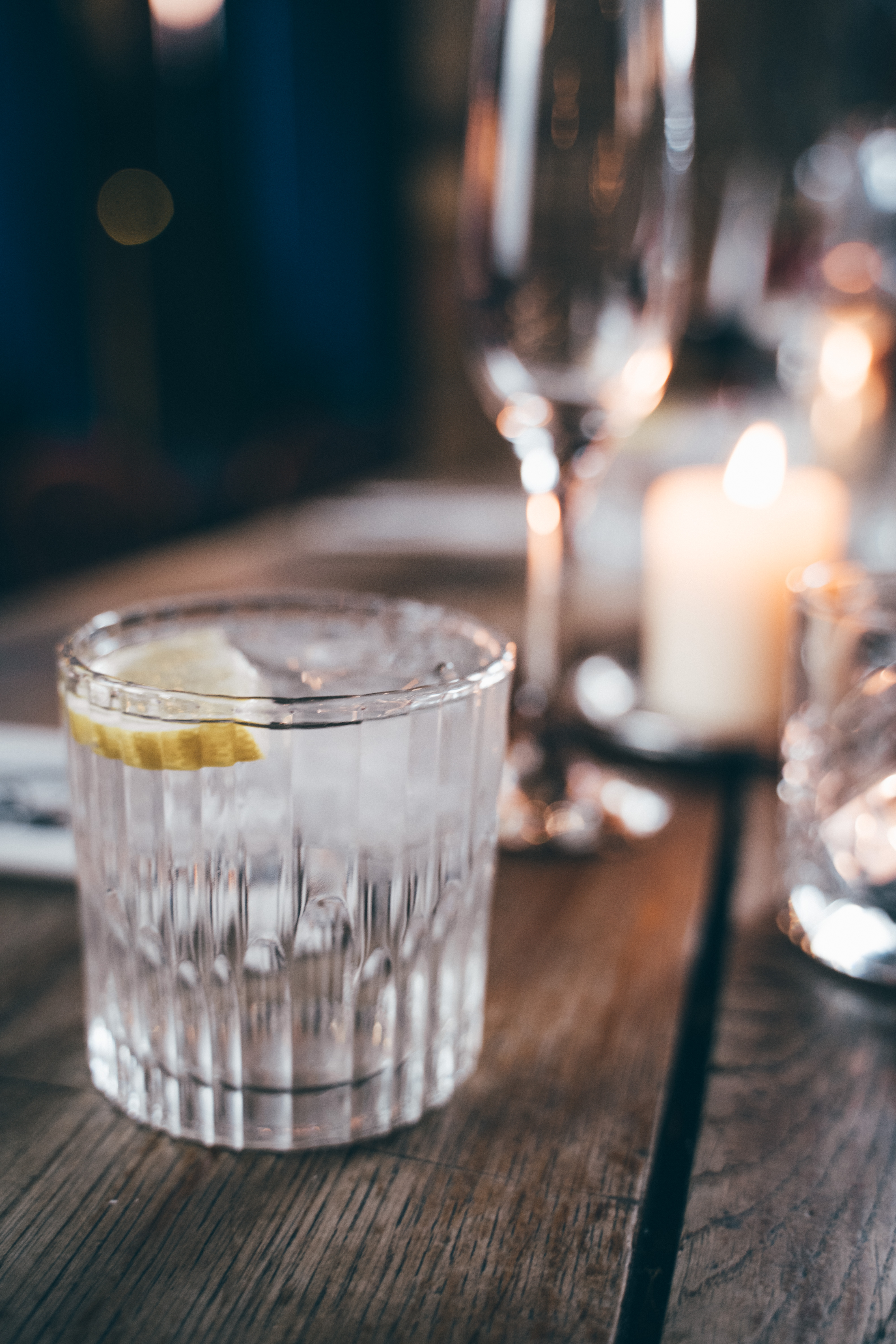 Elegant table setting at Oslo Hackney with lemon water, wine glass, and candle for events.