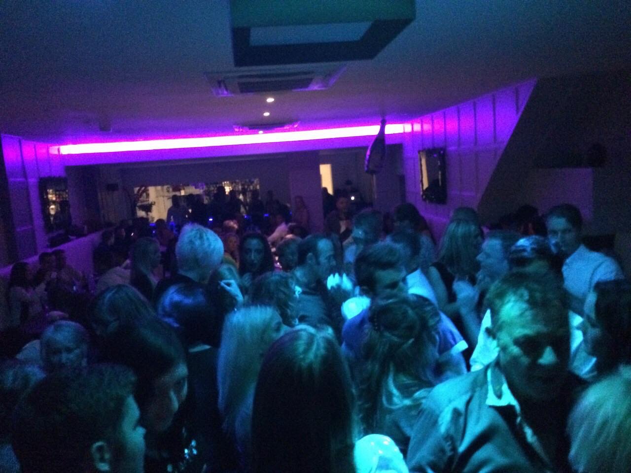 Vibrant event space at Orama Restaurant with purple lighting for networking and celebrations.