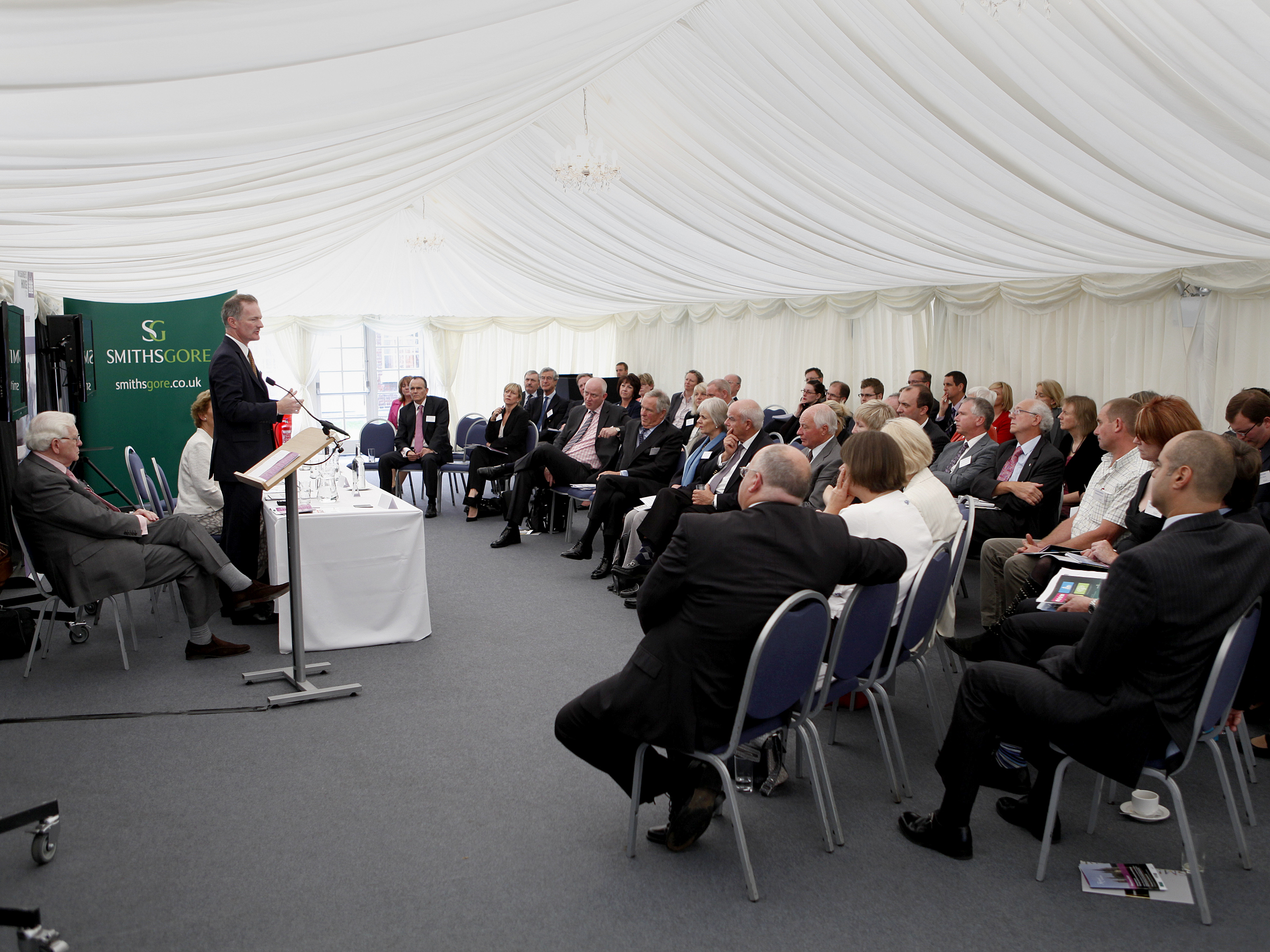 Commissioner's House event with speaker in marquee, ideal for networking and knowledge sharing.