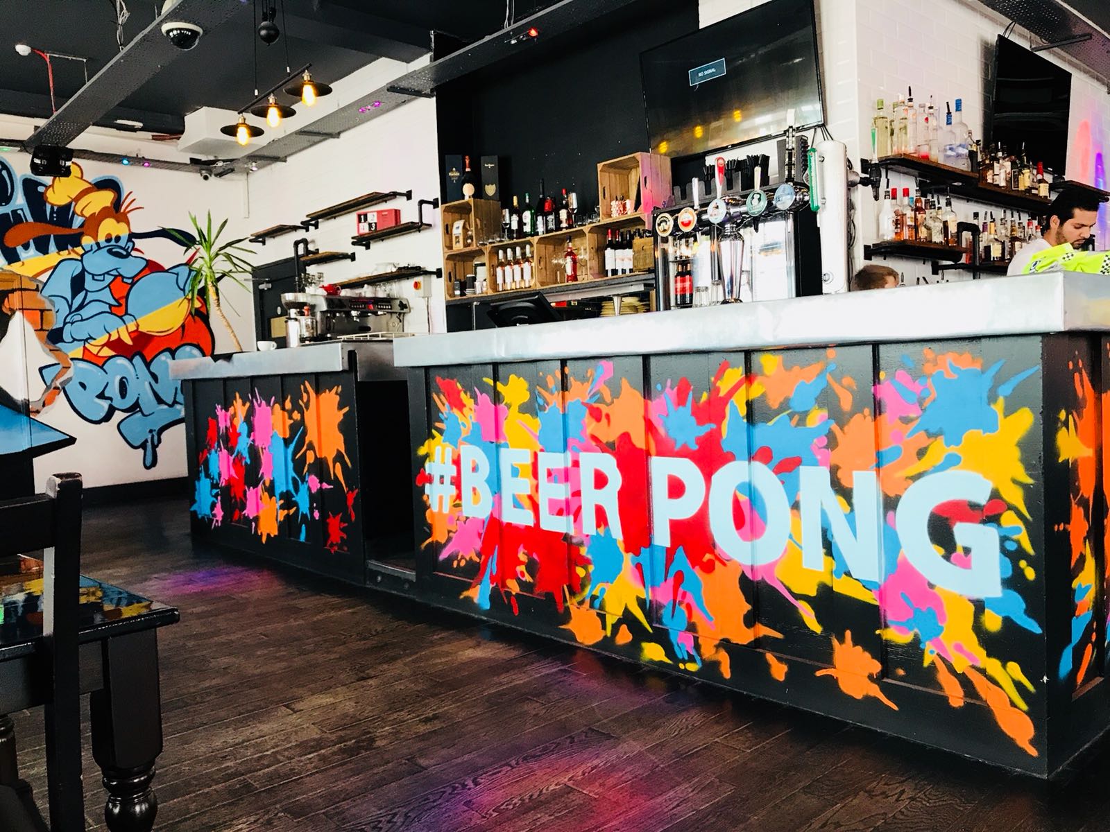 Vibrant Main Bar in Shoreditch with colorful beer pong setup for social events.