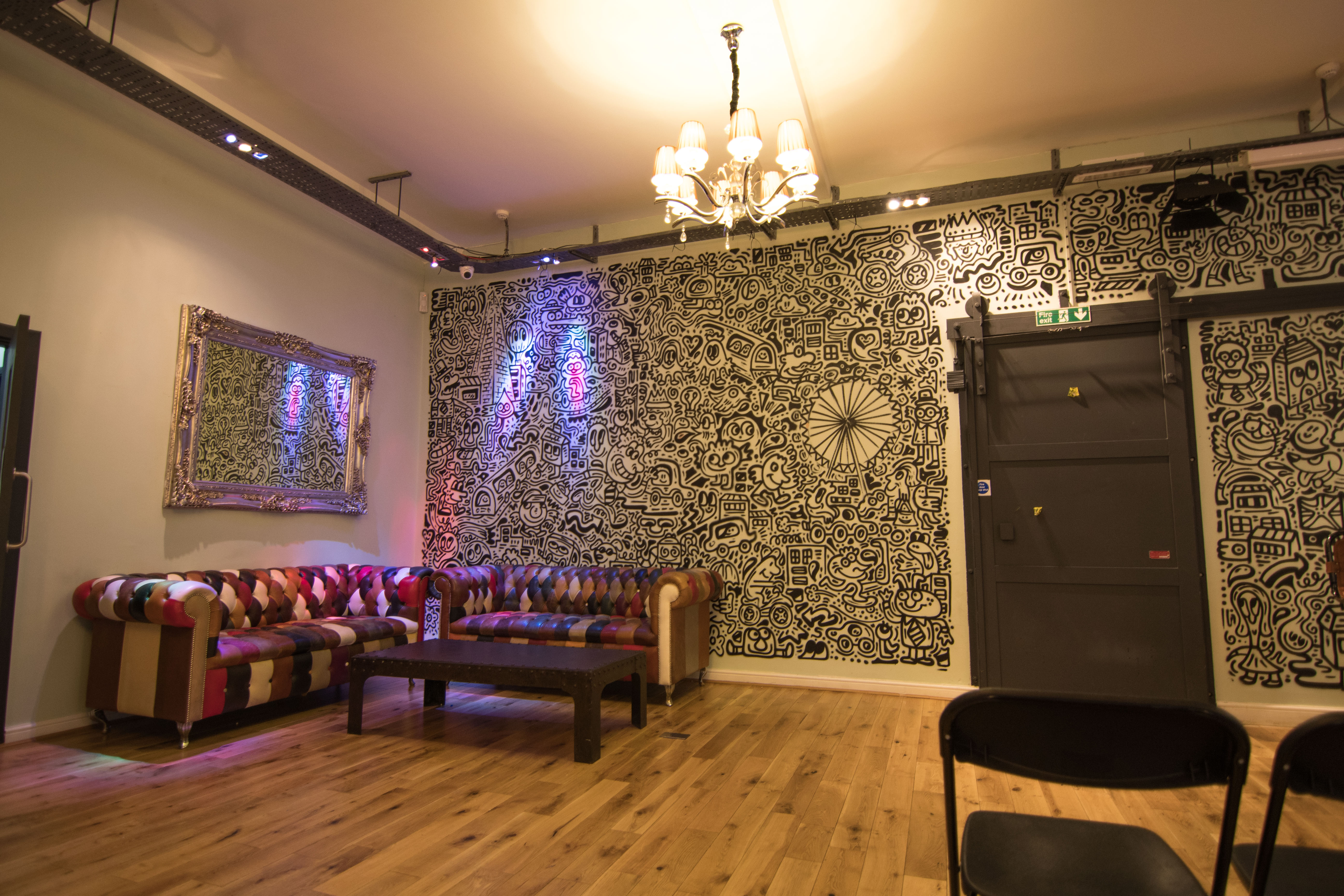 Stylish event space with vibrant sofa and mural, perfect for networking or workshops.