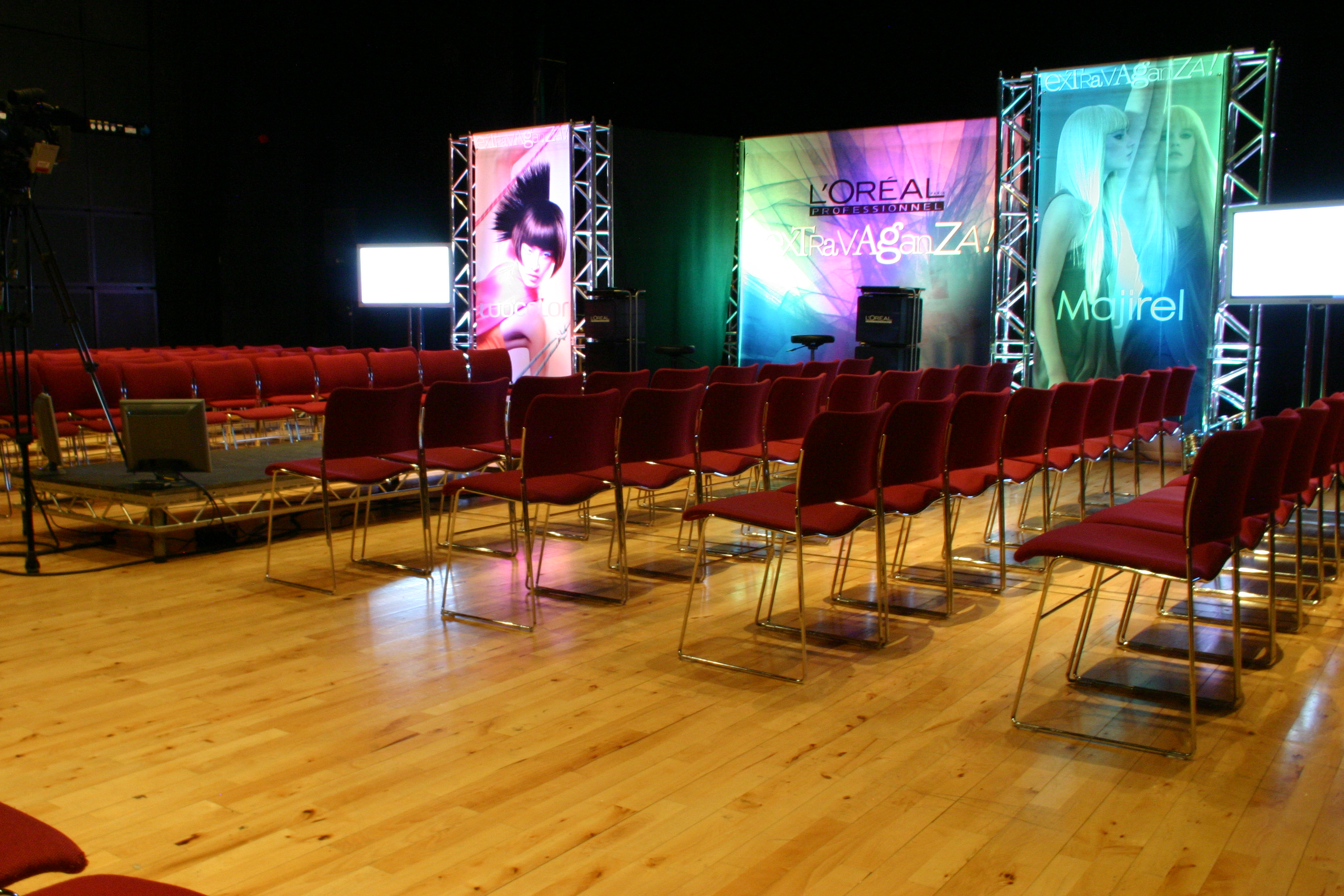 Corporate event setup at Birmingham Hippodrome with branded panels and red chairs.