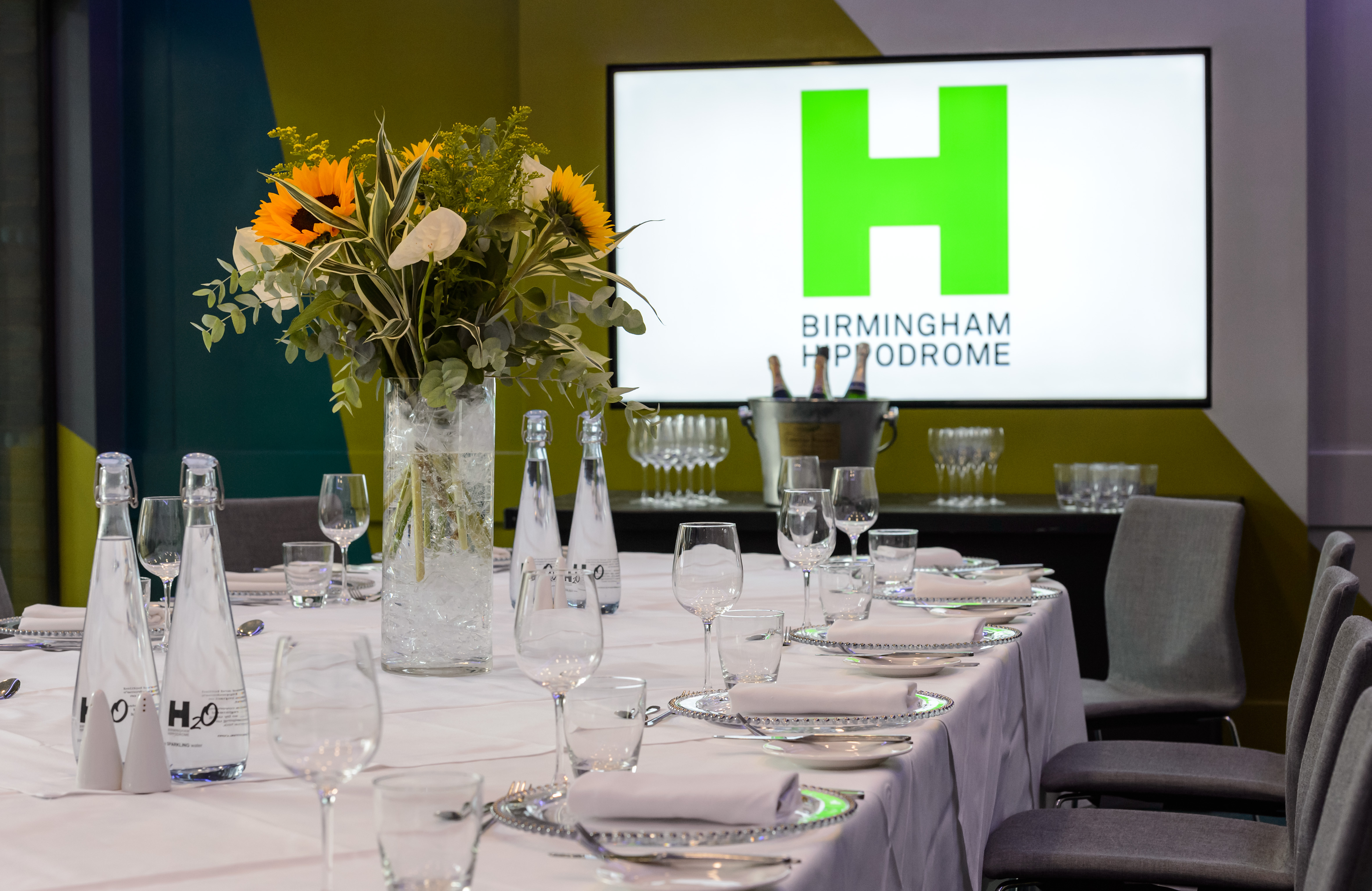 Elegant corporate meeting space at Birmingham Hippodrome with floral centerpiece.