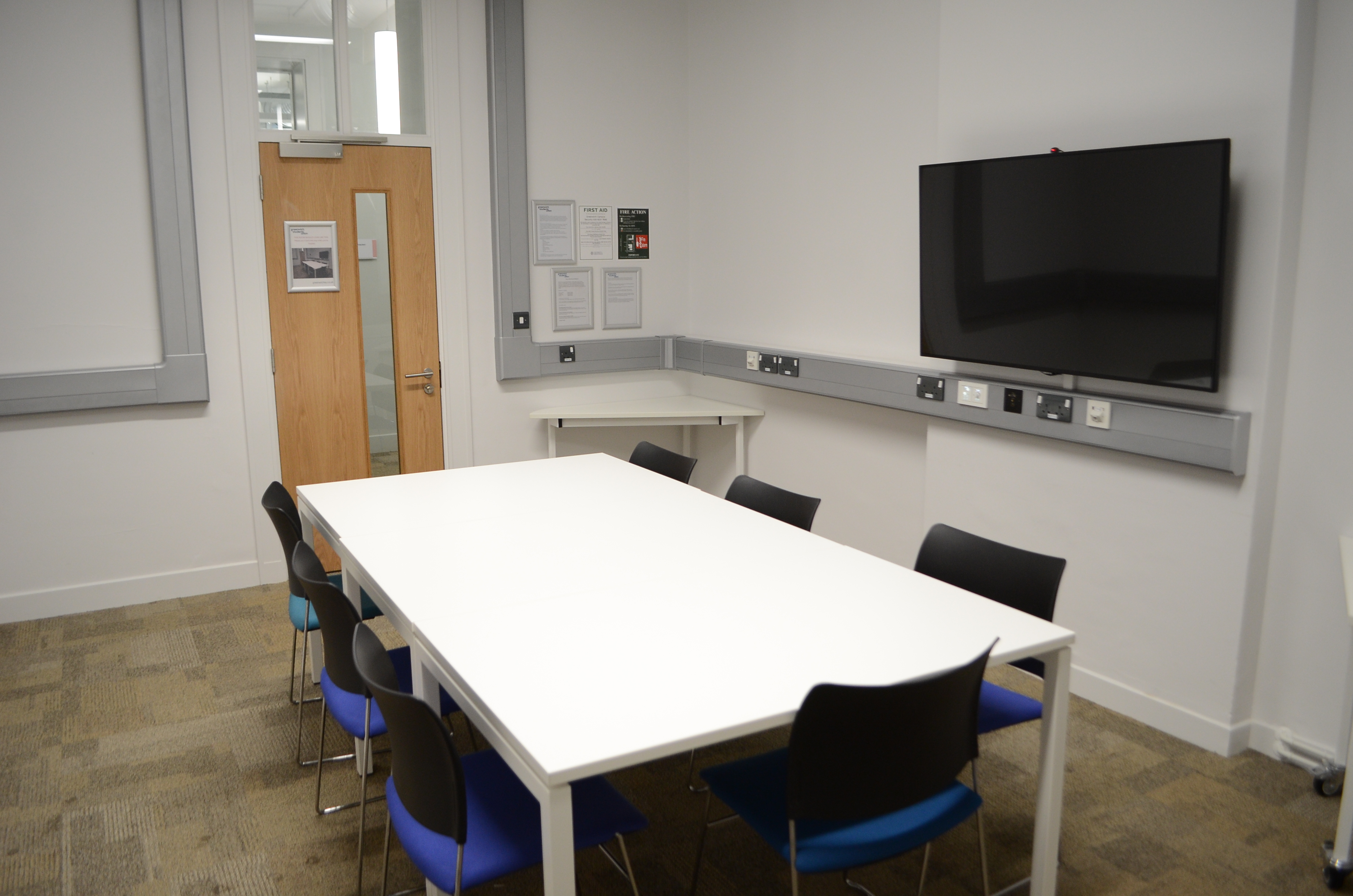 Modern small meeting room with large table, ideal for presentations and brainstorming.