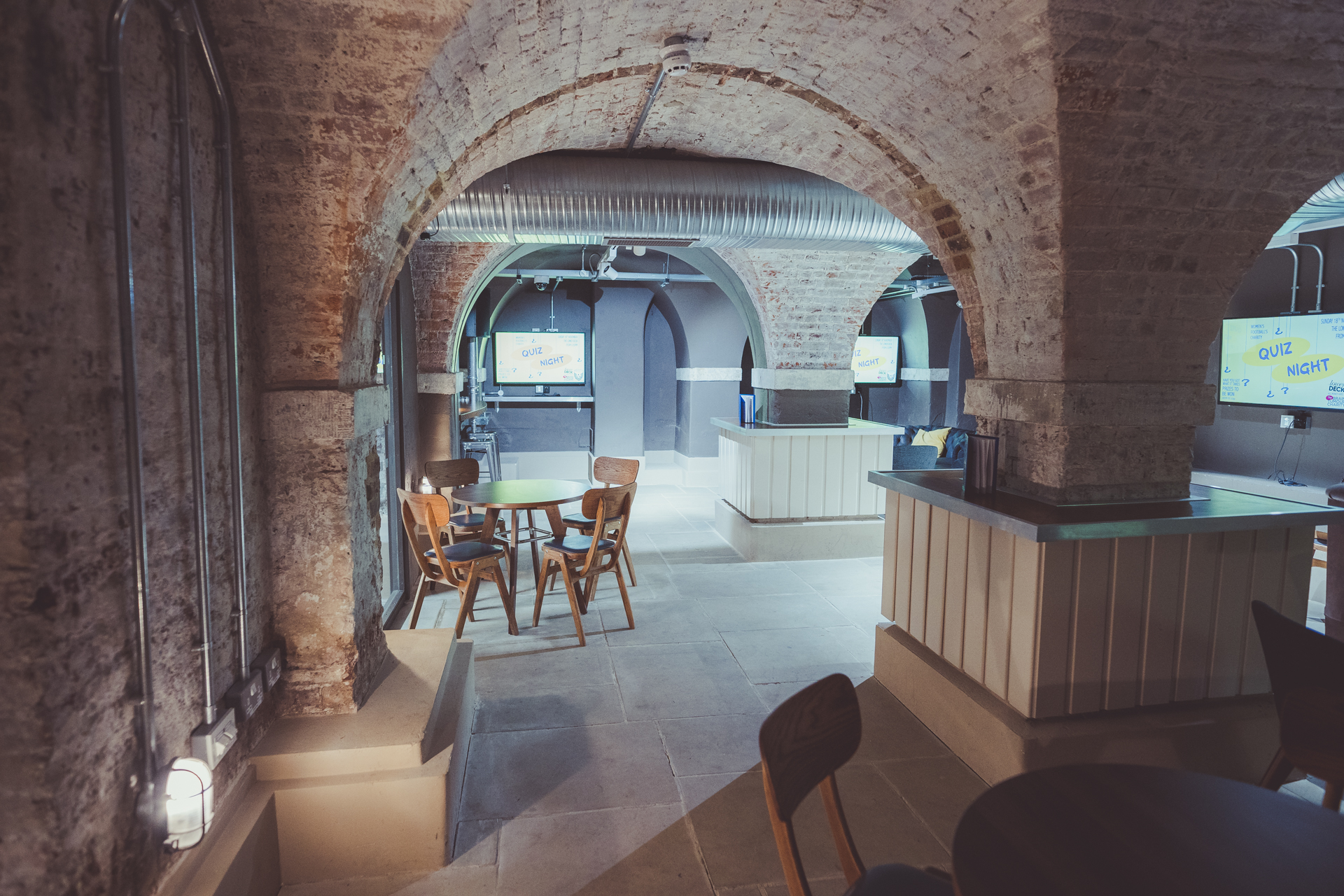 Versatile event space with exposed brick arches, ideal for meetings and presentations.