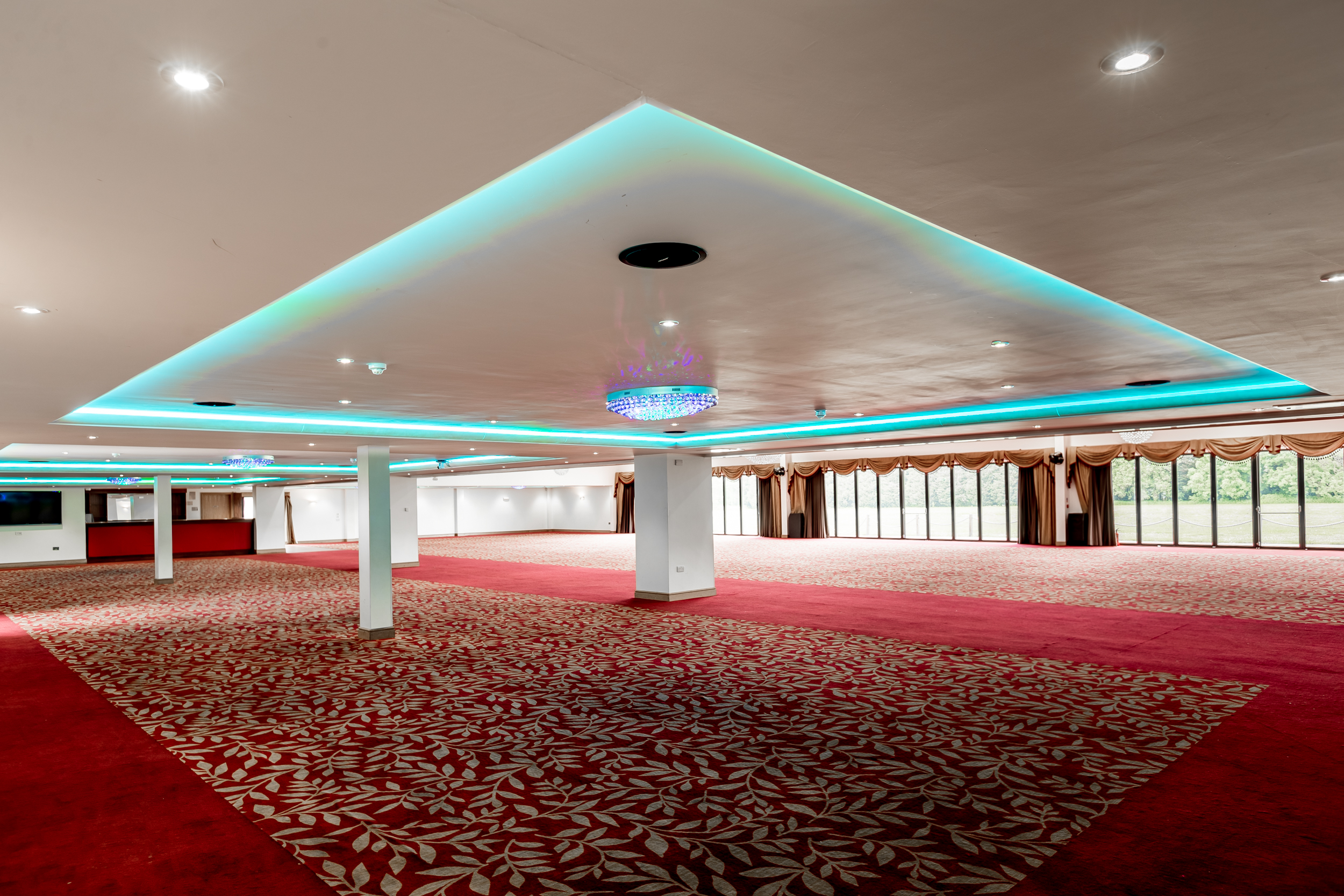 Spacious modern event venue with vibrant lighting, ideal for conferences and banquets.