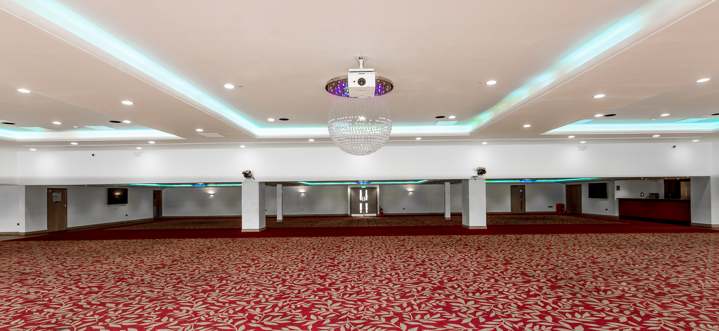 Spacious event venue with elegant chandelier for conferences and banquets.