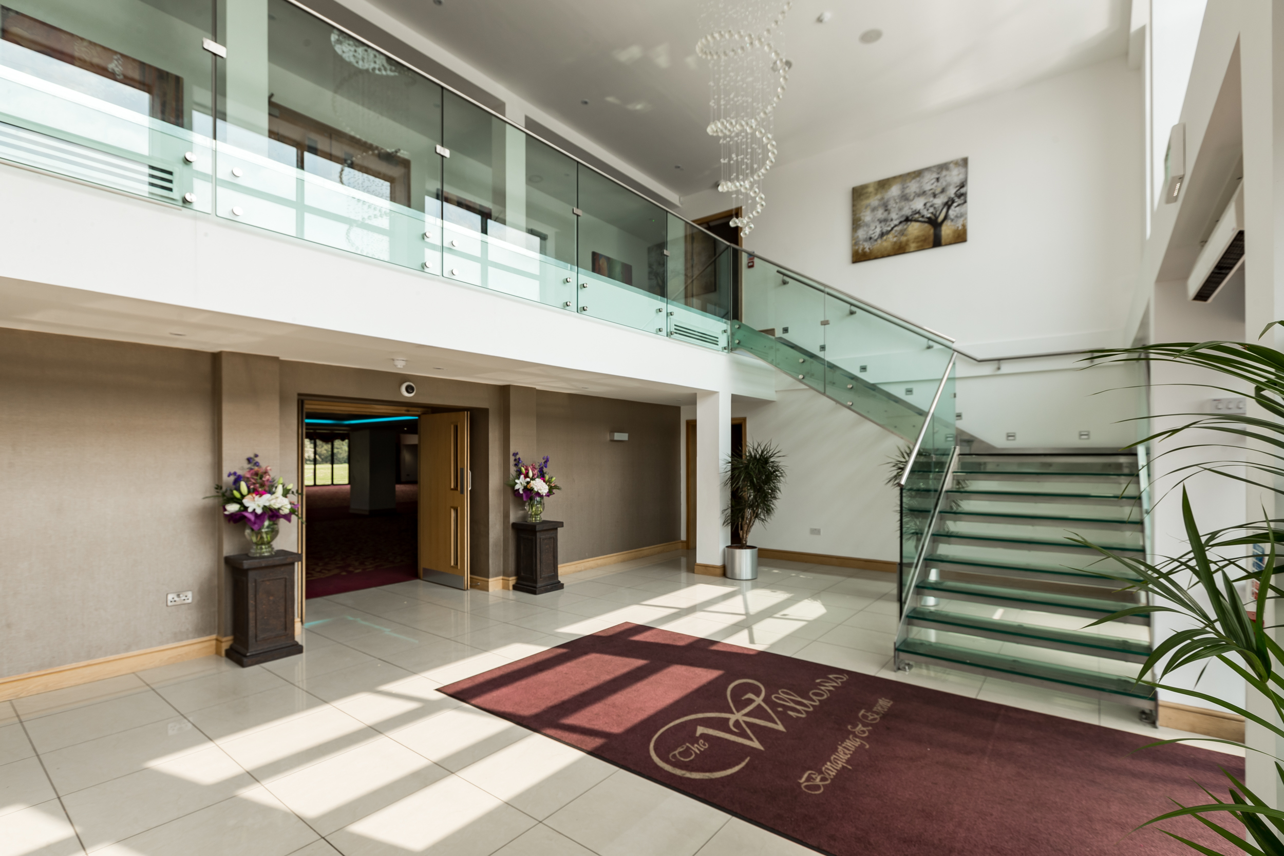 Spacious ballroom with elegant chandelier, ideal for events and networking.