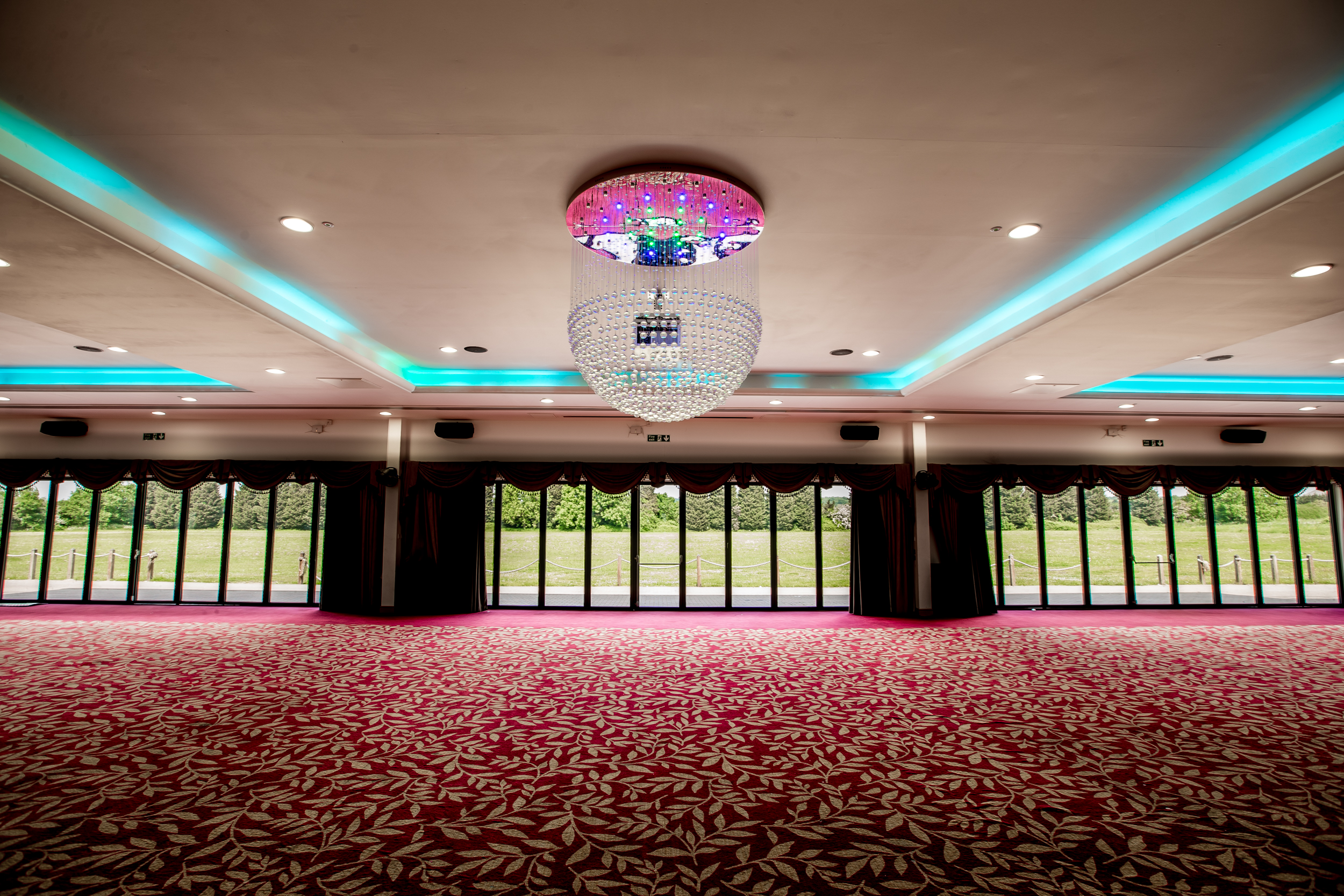 Elegant ballroom with chandelier, perfect for weddings and corporate events.