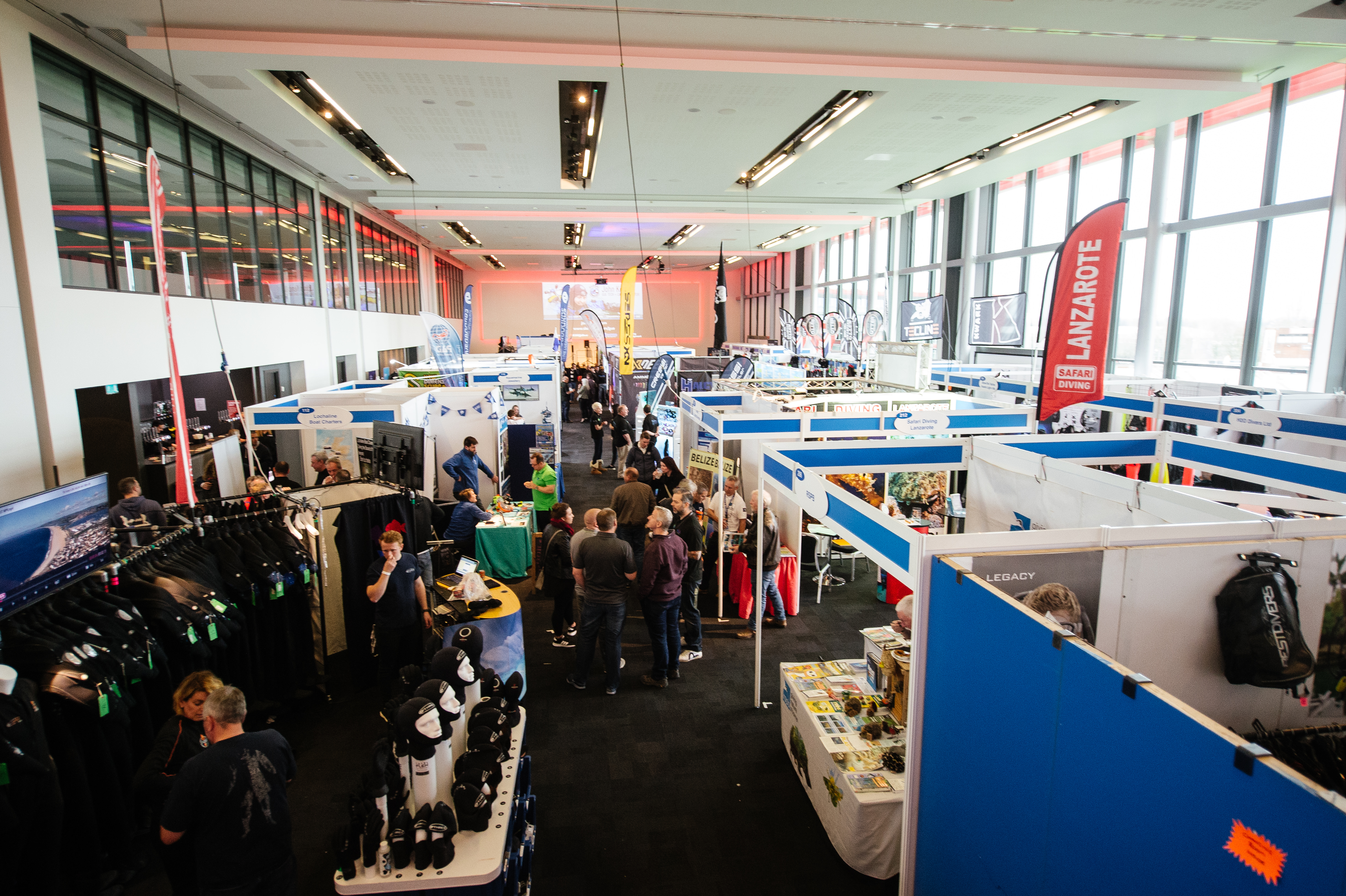 Bustling trade show at The Point, Emirates Old Trafford with vibrant vendor booths.
