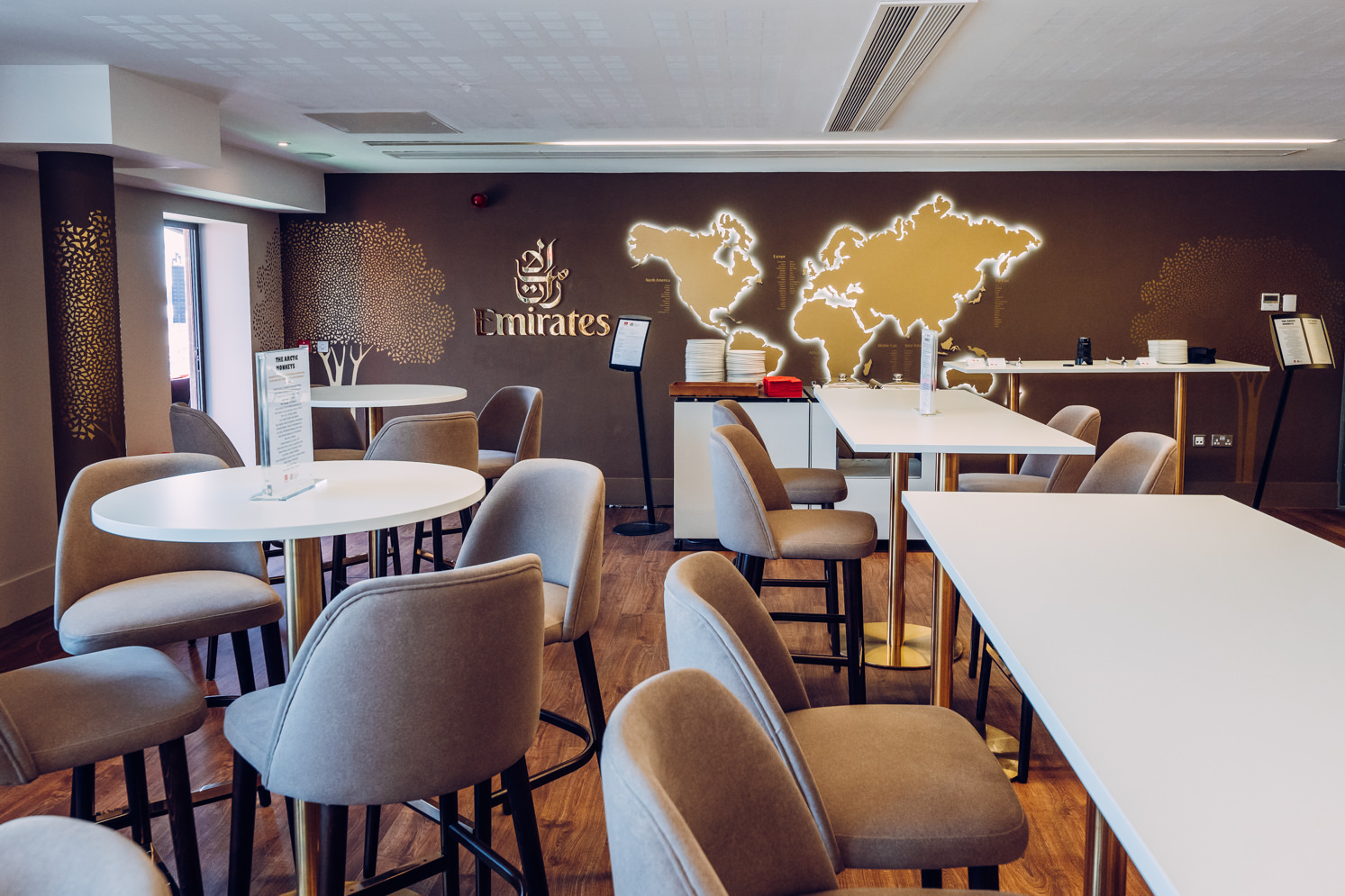 Emirates Lounge at Old Trafford: modern meeting space with high-top tables for corporate events.