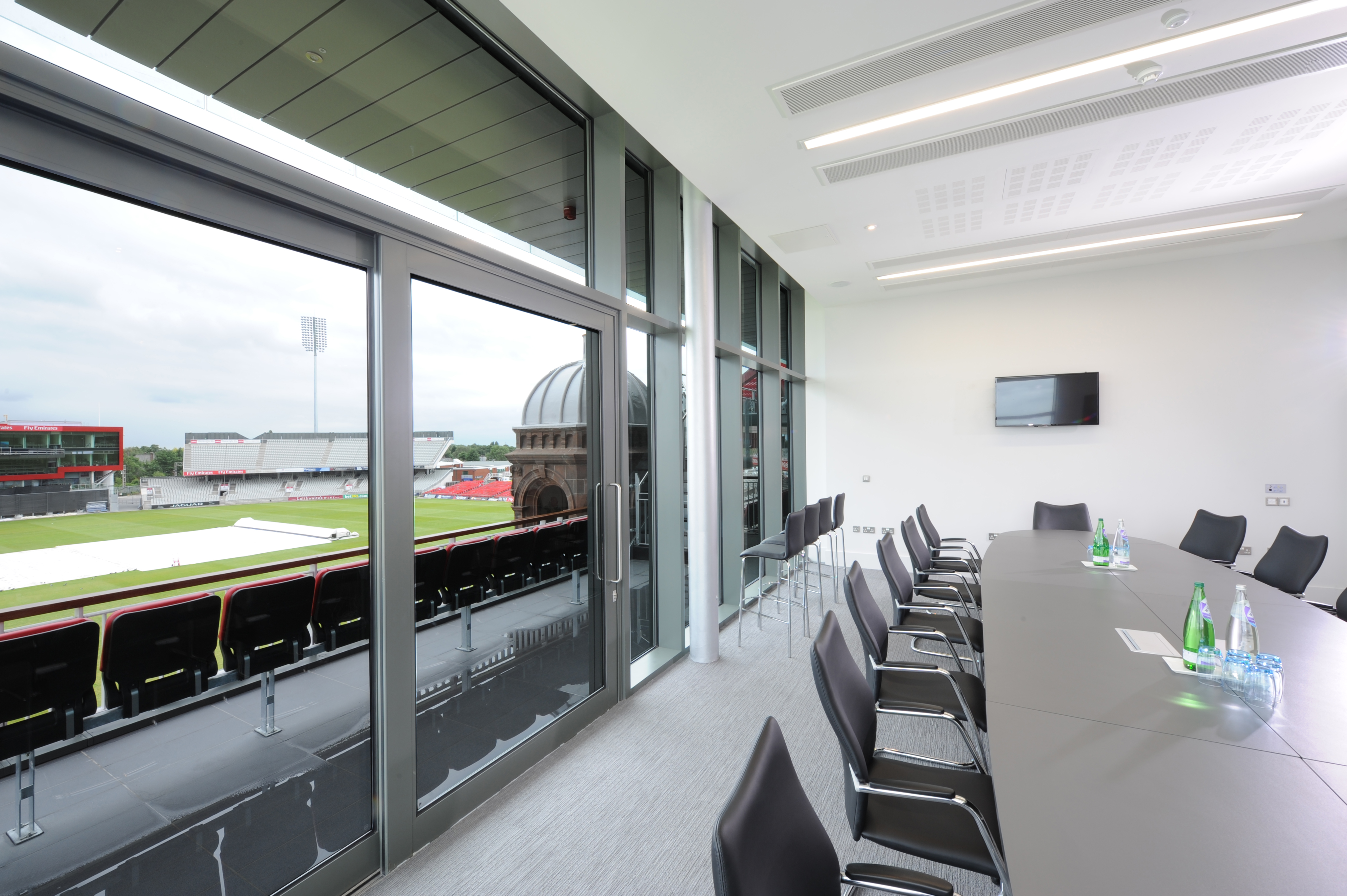 Modern meeting room at Emirates Old Trafford with large table, ideal for corporate events.