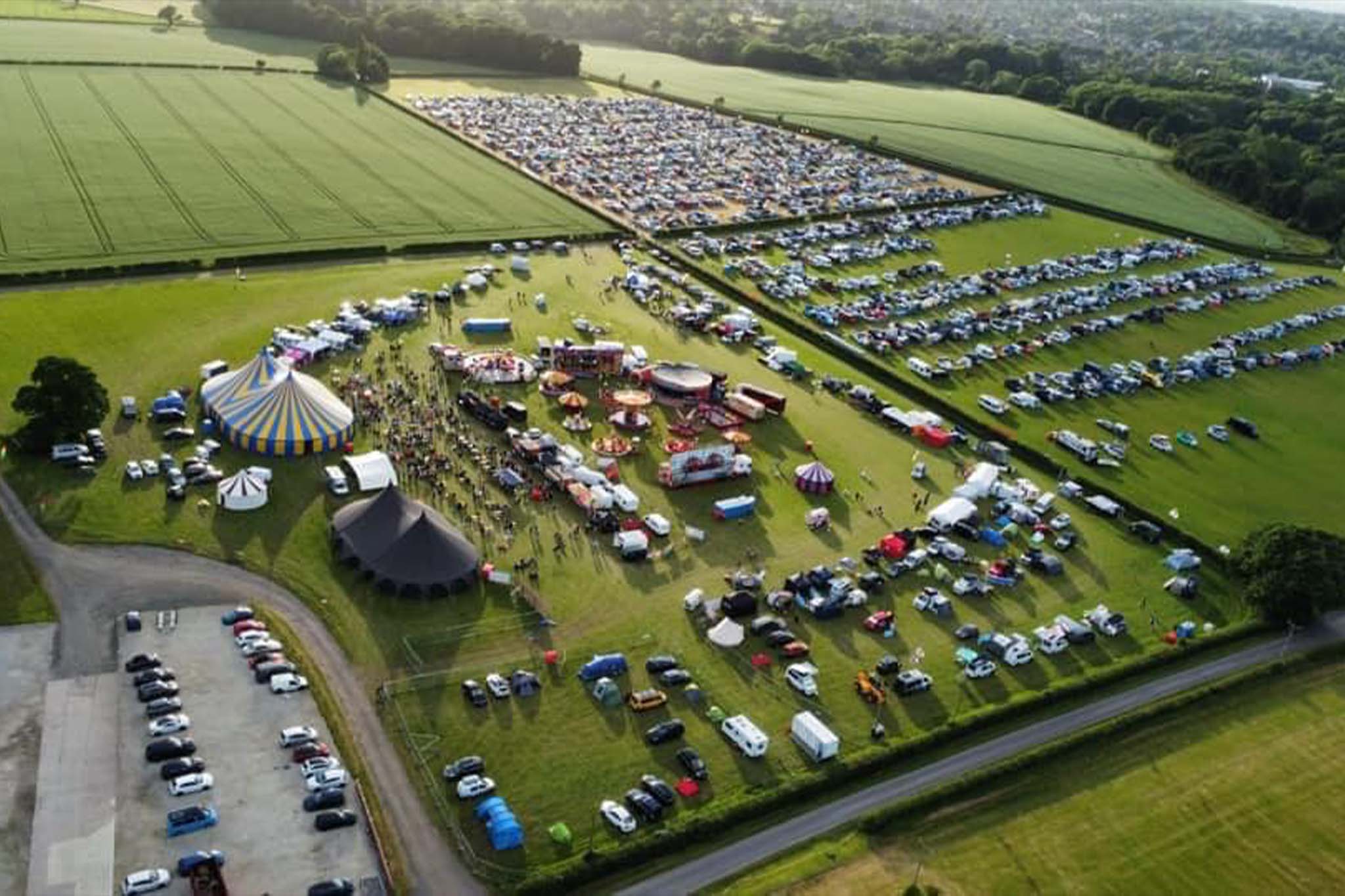 Outdoor festival setup at Ashley Showground with vibrant tents and green fields.