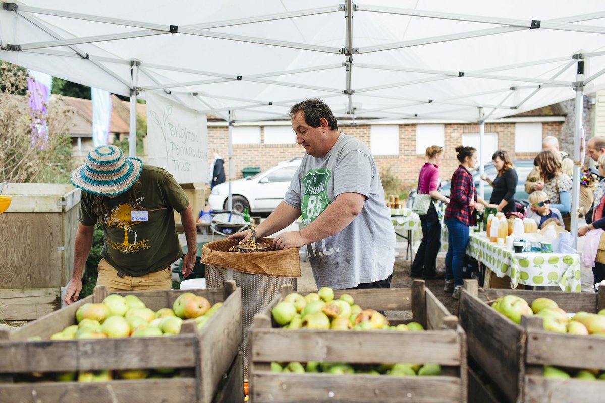 Vibrant outdoor market with fresh produce in crates at Proud Country House event.