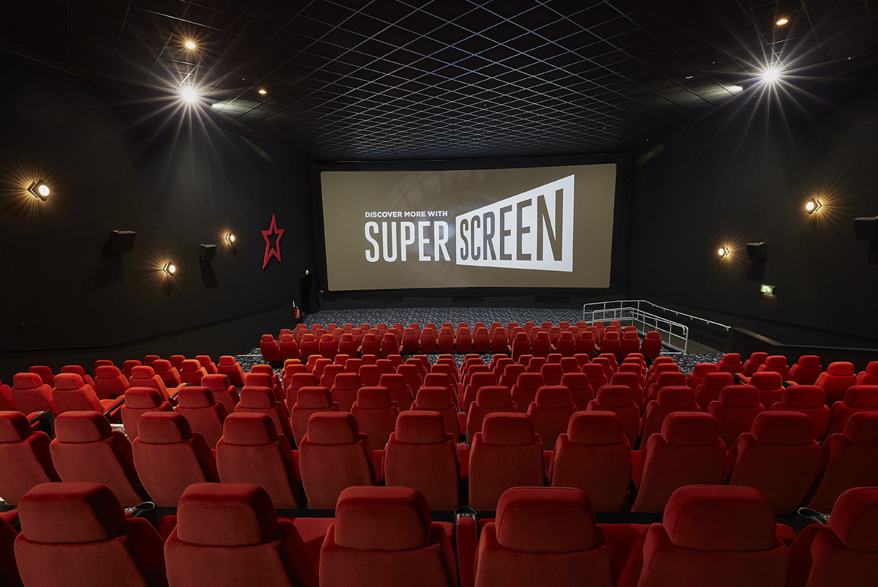 Medium screen cinema auditorium with plush red seating for film screenings and corporate events.