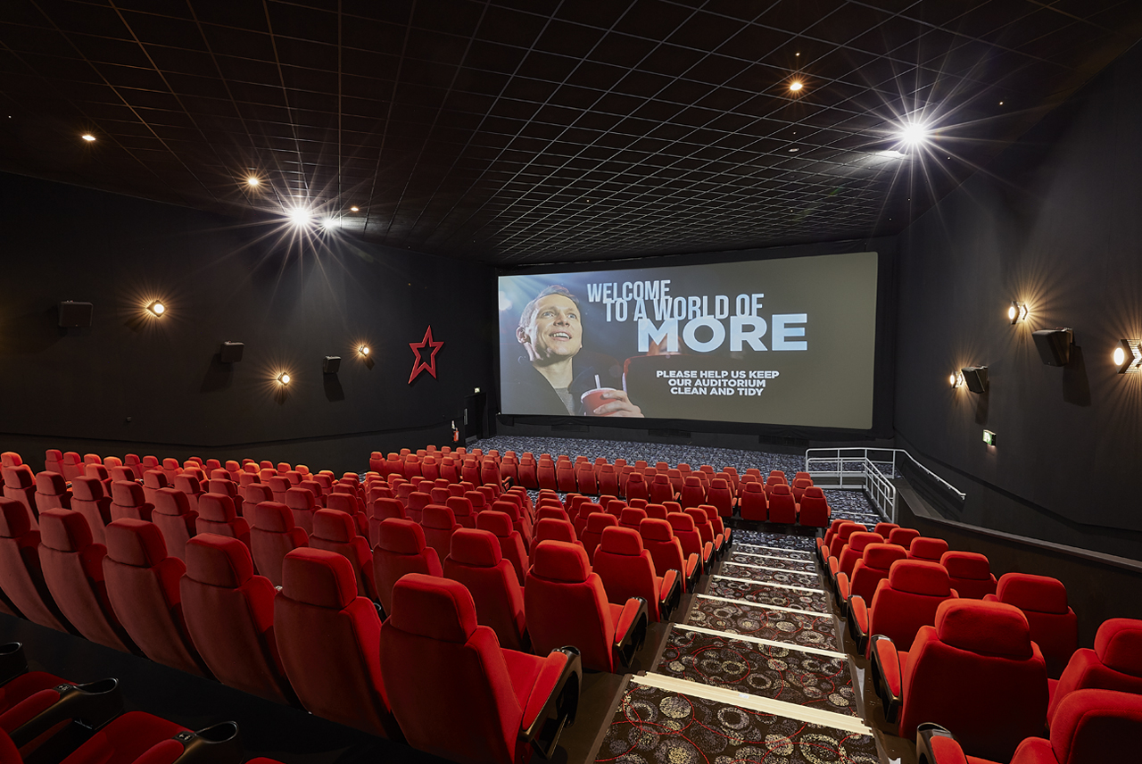 Medium screen cinema auditorium with plush red seating for corporate events and film screenings.